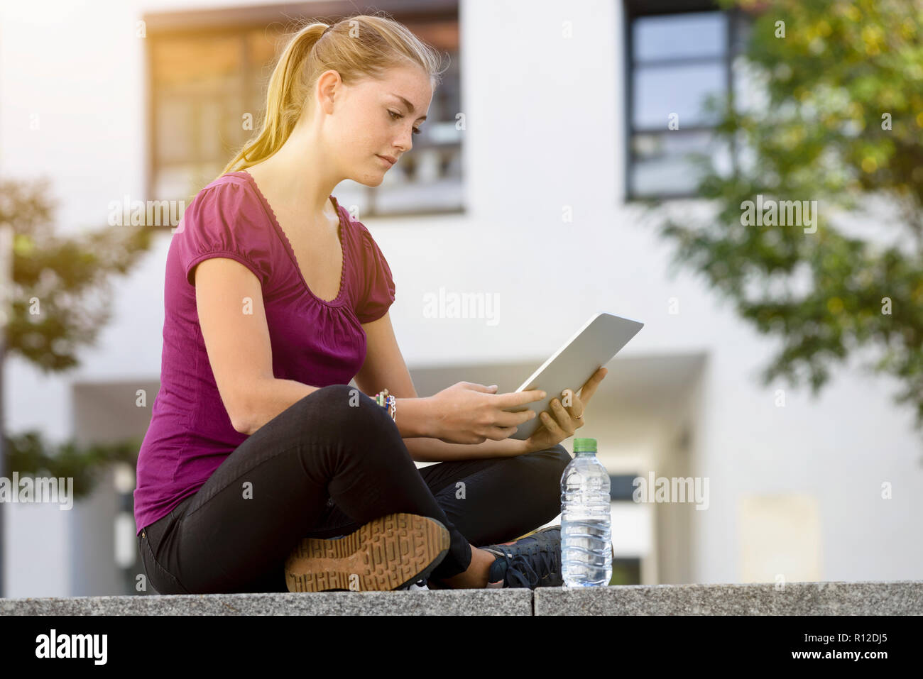 Young woman using digital tablet in park Banque D'Images