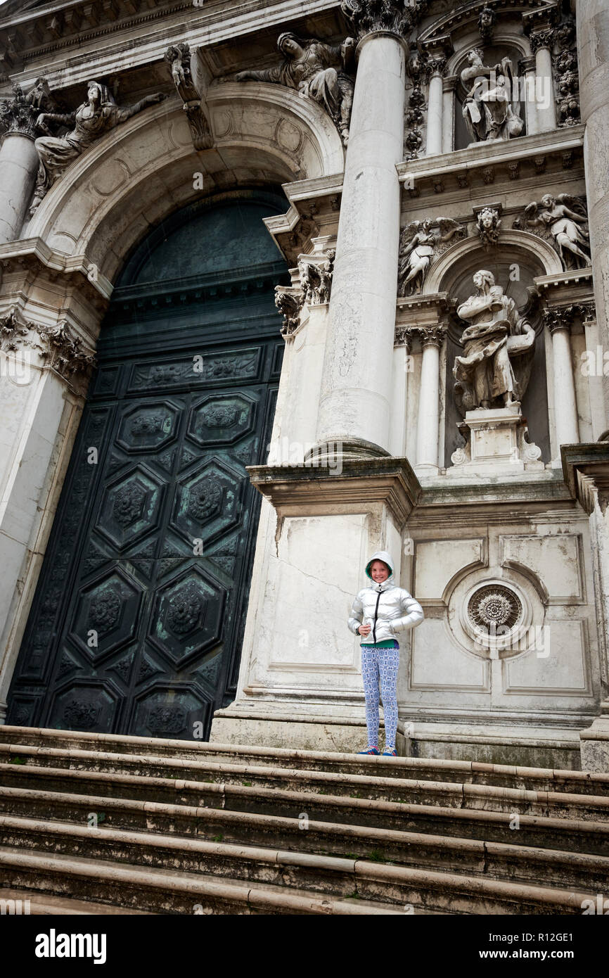 Une jeune fille se tient rien contre la porte de l'église Chiesa di Santa Maria del Rosario. Banque D'Images