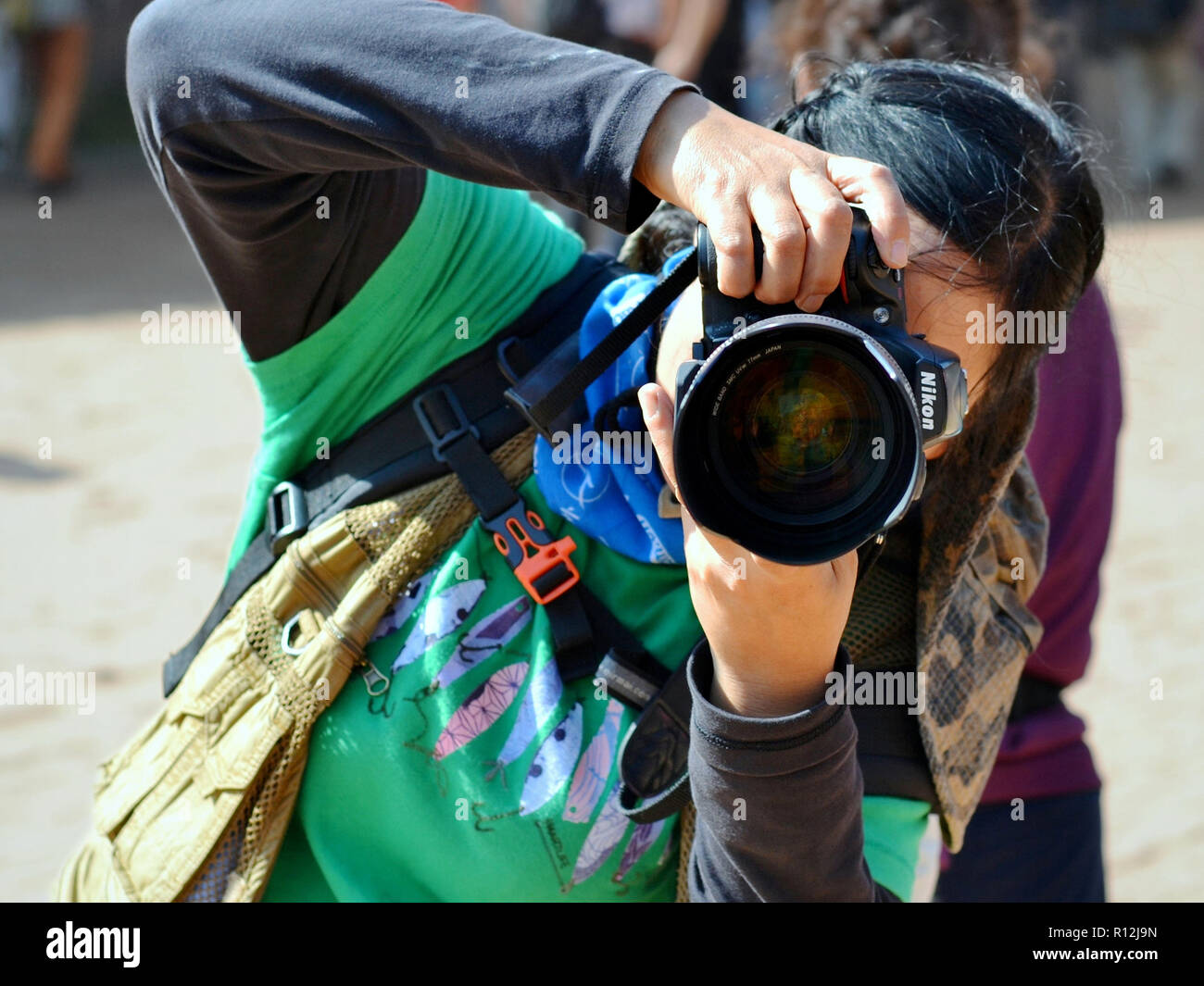 Photographe de la rue de sexe féminin chinois prend une photo et miroirs un autre photographe. Banque D'Images