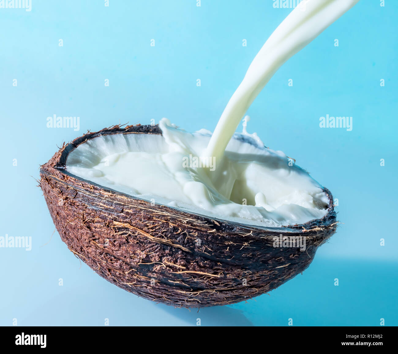 Avec du lait de coco splash sur un fond bleu, les éclaboussures de lait de coco Banque D'Images