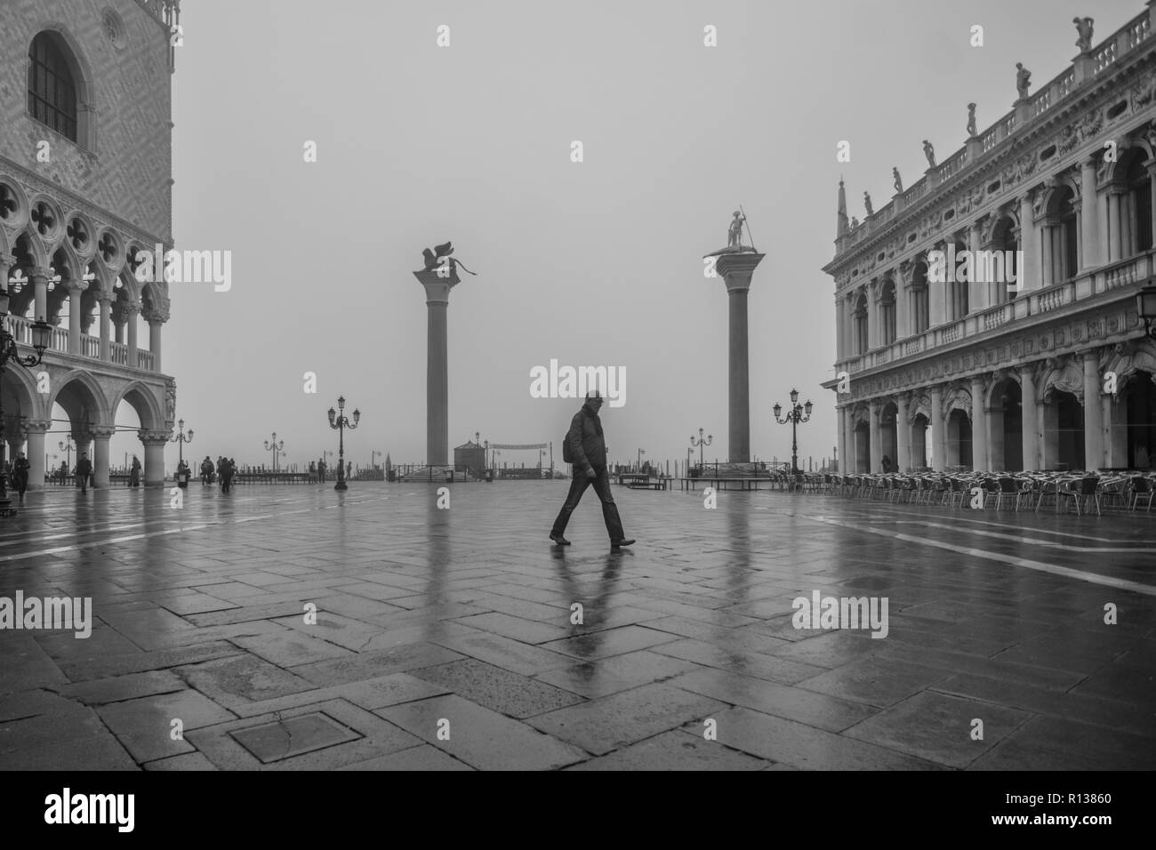 Venise, Italie. 09 novembre, 2018. [Cette photo a été converti en noir et blanc] un homme marche dans la place St Marc alors que la ville est plongée dans un brouillard sur Novembre 09, 2018, à Venise, Italie. Venise se réveilla avec les premiers soft brouillard, appelé dans le dialecte vénitien 'Caligo'. © Simone Padovani / éveil / Alamy Live News Banque D'Images
