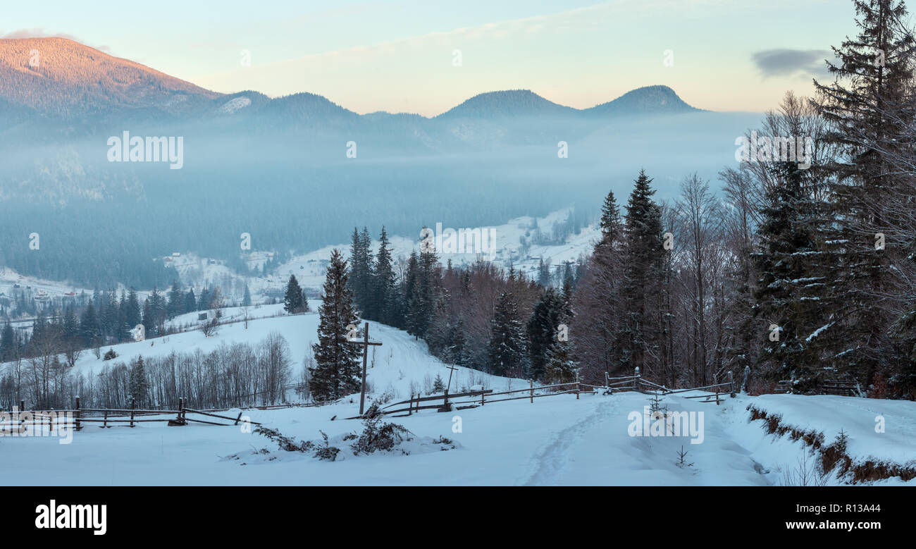 Village de montagne Hiver matin lever de périphérie en noir Cheremosh river valley entre Alp. Vue du chemin couvert de neige en milieu rural sur la pente avec ch Banque D'Images