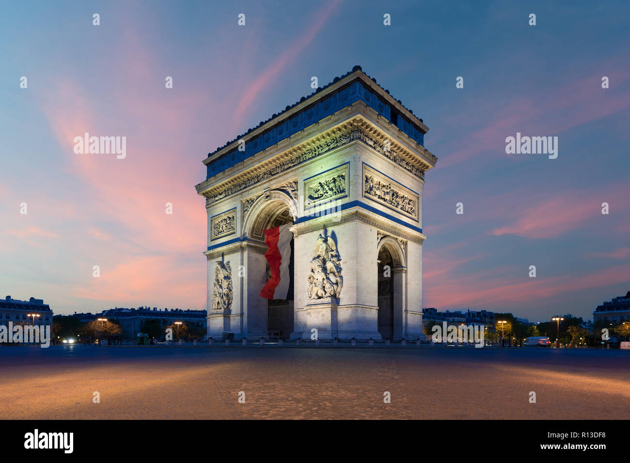 Arc de Triomphe et des Champs Elysées de Paris avec un grand drapeau de la France sous l'arche en Europe le jour de la victoire à Paris, France. Banque D'Images