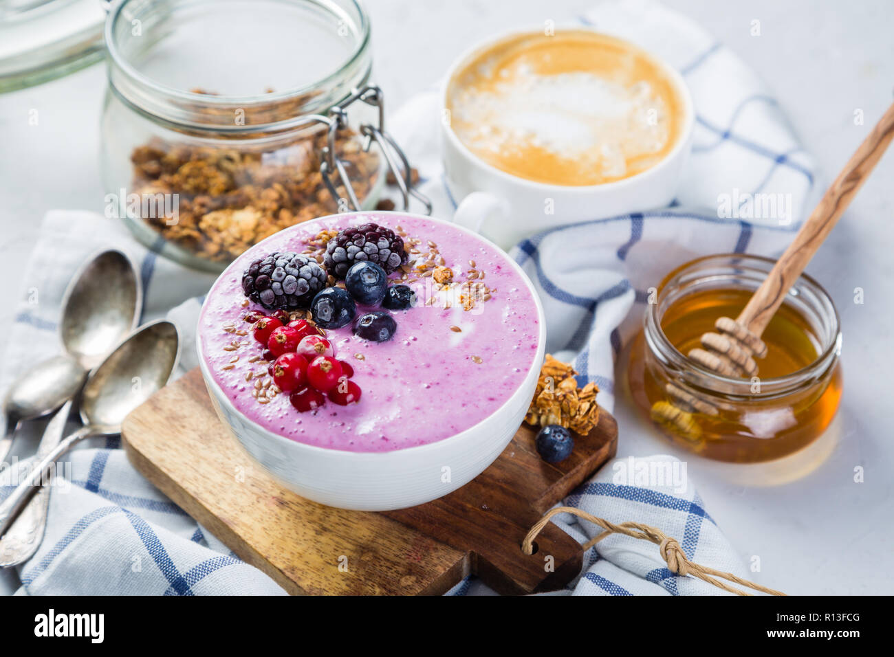 Petit déjeuner - bol de yogourt avec granola et fruits rouges, café, miel Banque D'Images