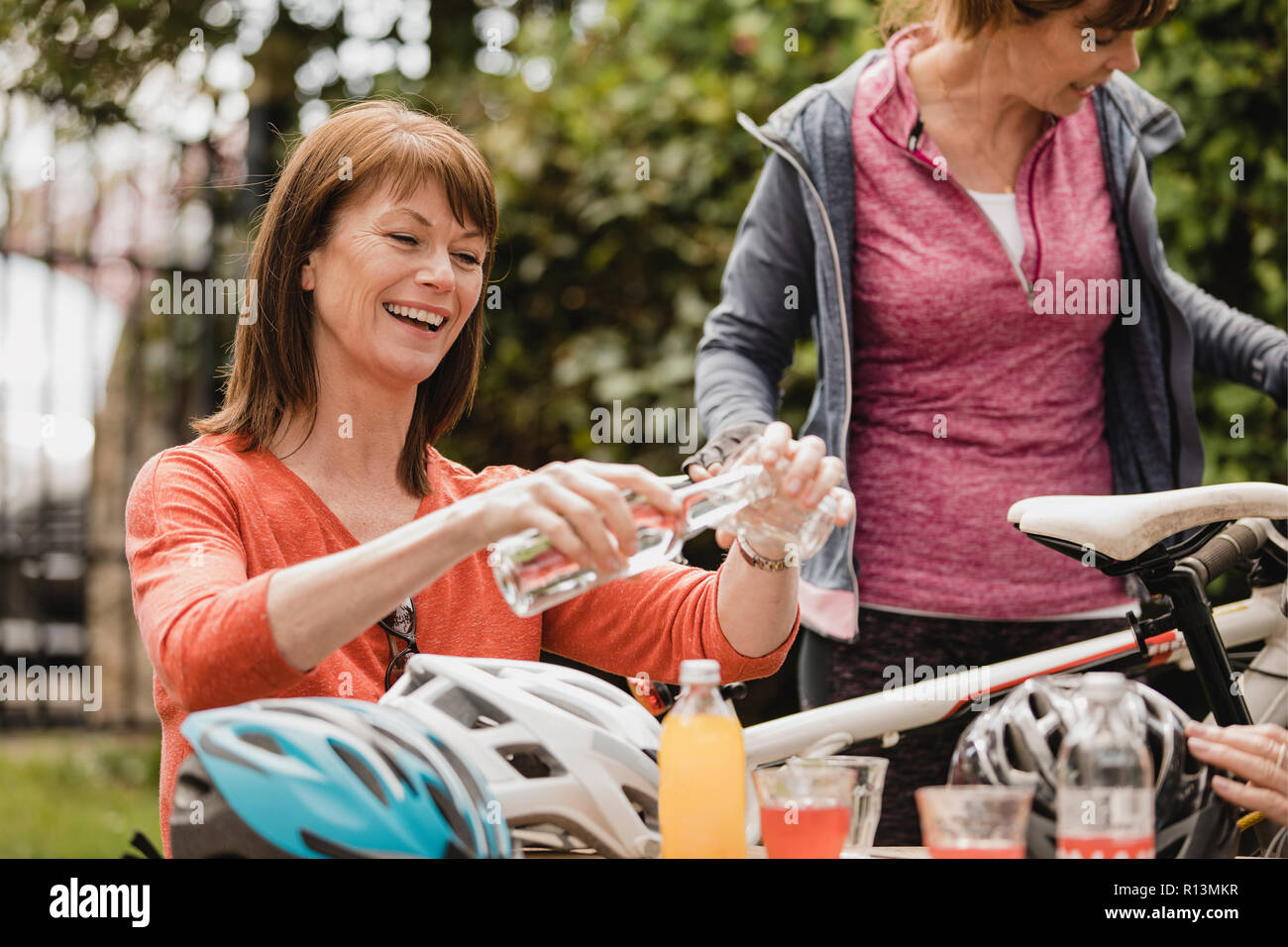 Petit groupe de cyclistes de sexe féminin sont assis dans le coin salon extérieur d'un café. Tey profitent de quelques rafraîchissements à mesure qu'ils prennent une pause. Banque D'Images