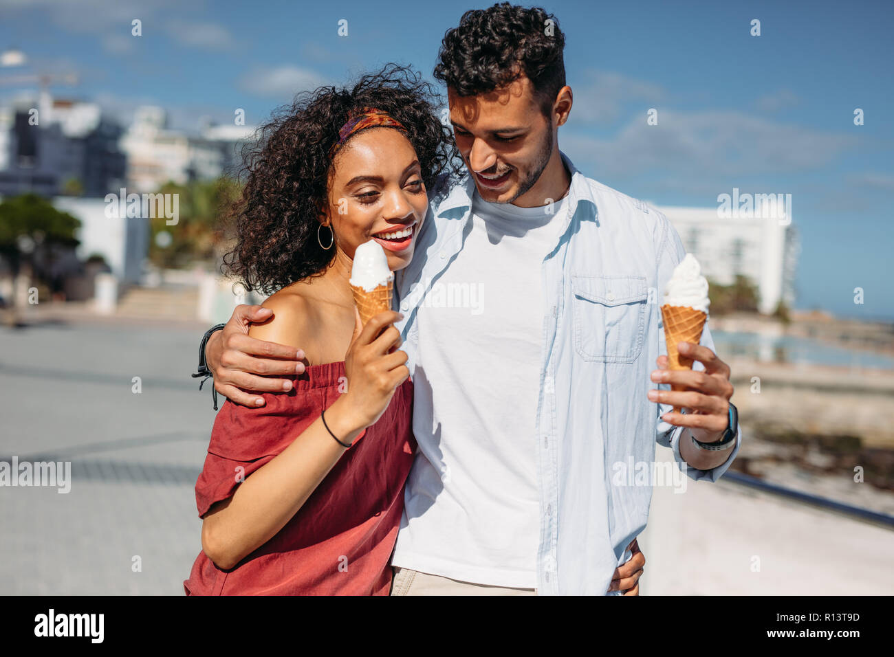 Couple in love walking on city street de manger des glaces. Jeune homme et  femme de passer du temps ensemble à parler de la rue et la consommation de  crème glacée Photo