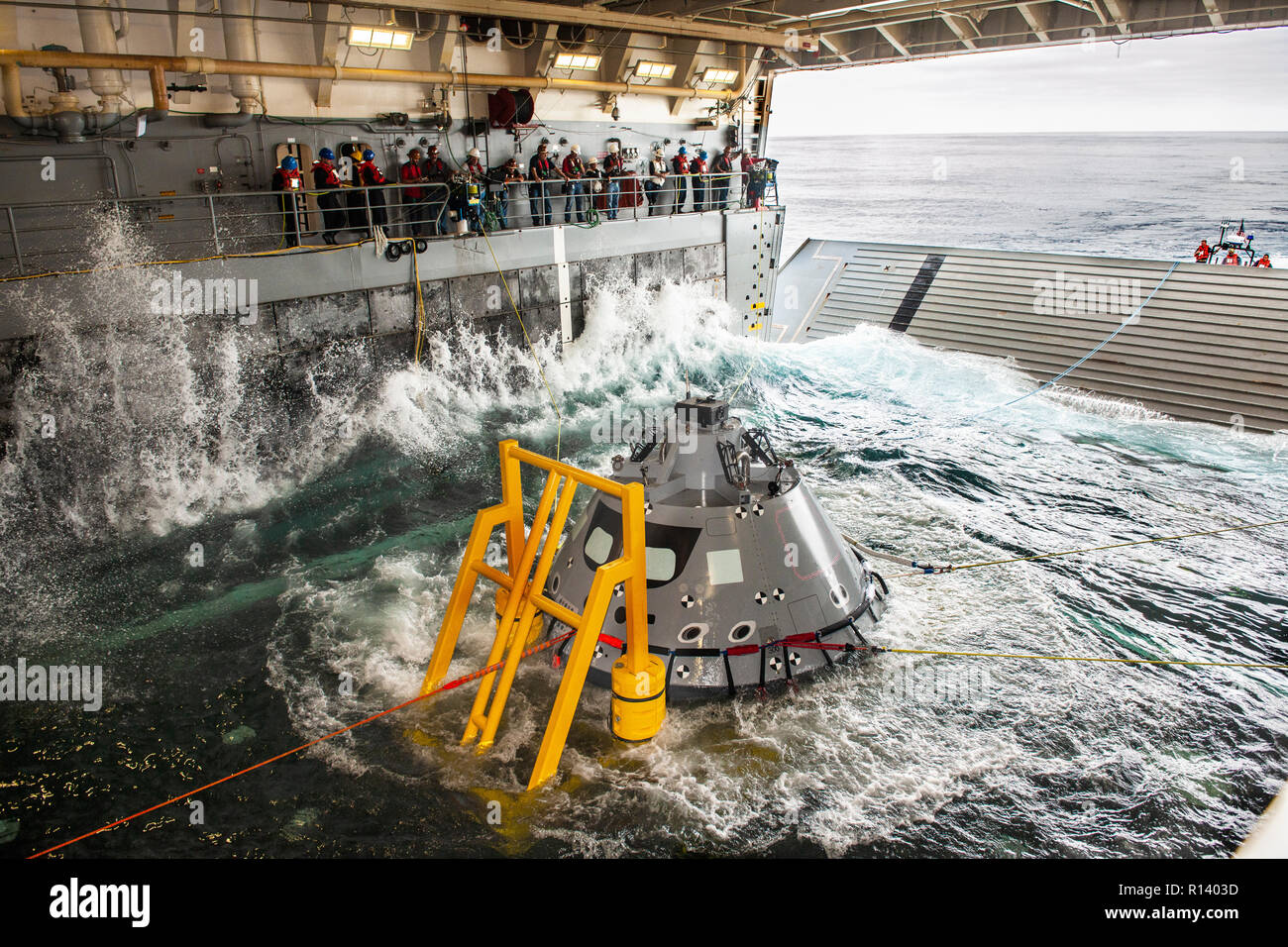 Les membres de l'équipe de rétablissement de la NASA watch comme une version d'essai de la capsule Orion est attiré dans le même pont de l'USS John P. Murtha lors d'un test de récupération, 30 octobre 2018 dans l'océan Pacifique. La NASA et la marine américaine n'a pas effectué l'océan ouvert récupération d'un vaisseau spatial habité depuis le projet Apollo dans les années 60 et sont des procédures d'essai et le matériel qui sera utilisé pour récupérer le vaisseau Orion après il éclaboussures vers le bas dans l'océan Pacifique à la suite des futures missions d'exploration spatiale. Banque D'Images