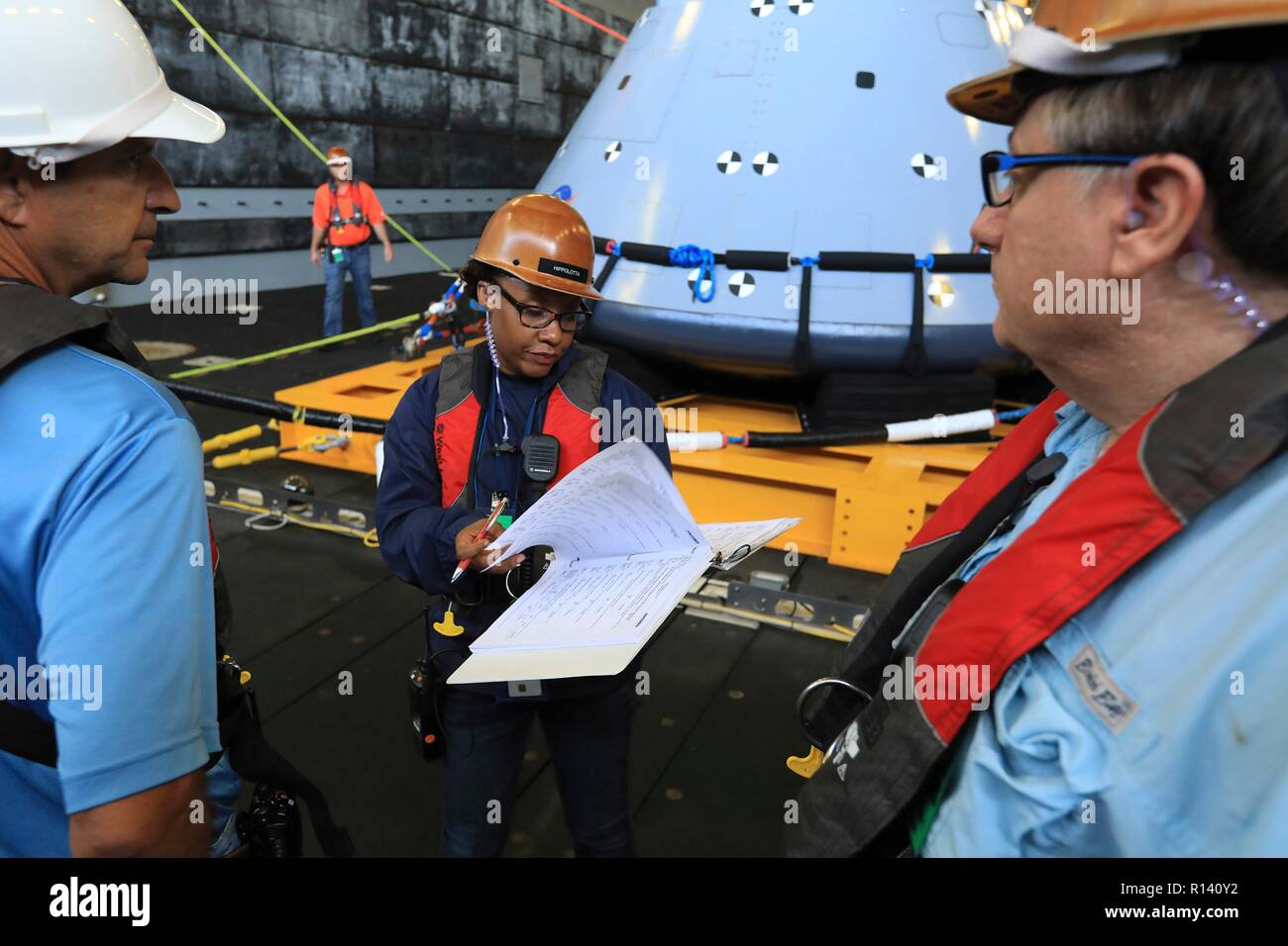 Tracy Parcs, centre, avec Jacobs, sert d'intégrateur des opérations de récupération en cours lors du test de récupération d'une maquette-7 version de la prochaine génération de capsule spatiale Orion dans le pont du coffre de l'USS John P. Murtha lors d'un test de récupération de l'océan ouvert le 31 octobre 2018 dans l'océan Pacifique. La NASA et la marine américaine n'a pas effectué l'océan ouvert récupération d'un vaisseau spatial habité depuis le projet Apollo dans les années 60 et sont des procédures d'essai et le matériel qui sera utilisé pour récupérer le vaisseau Orion après il éclaboussures vers le bas dans l'océan Pacifique à la suite des futures missions d'exploration spatiale. Banque D'Images