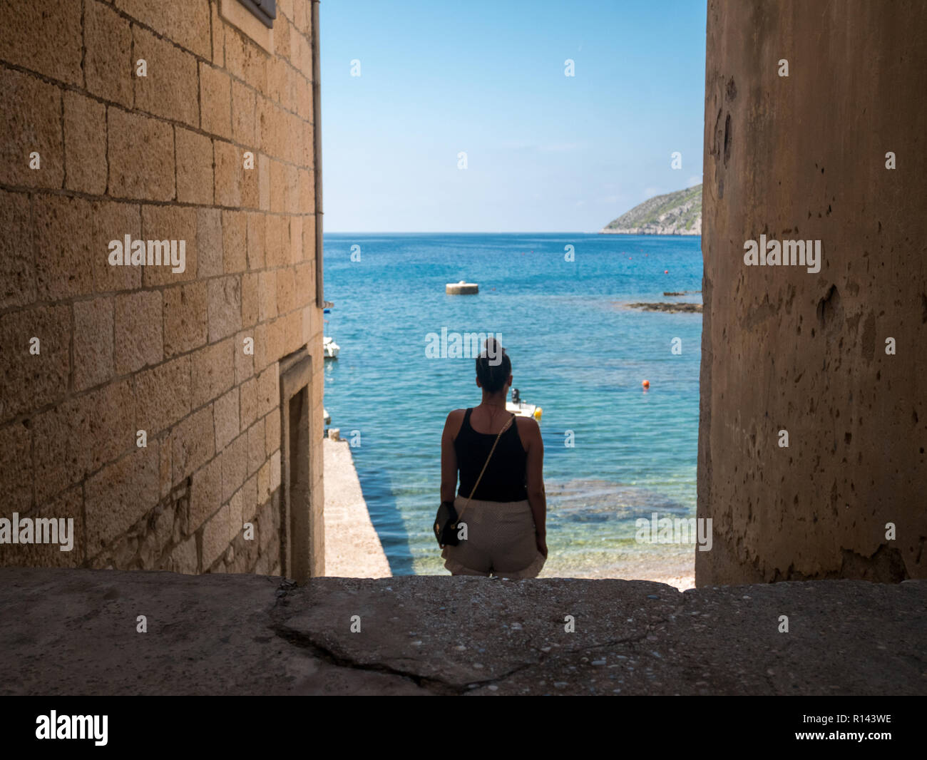 Femme marche sur le passage de la pierre à la mer à l'île de Vis en Croatie Banque D'Images