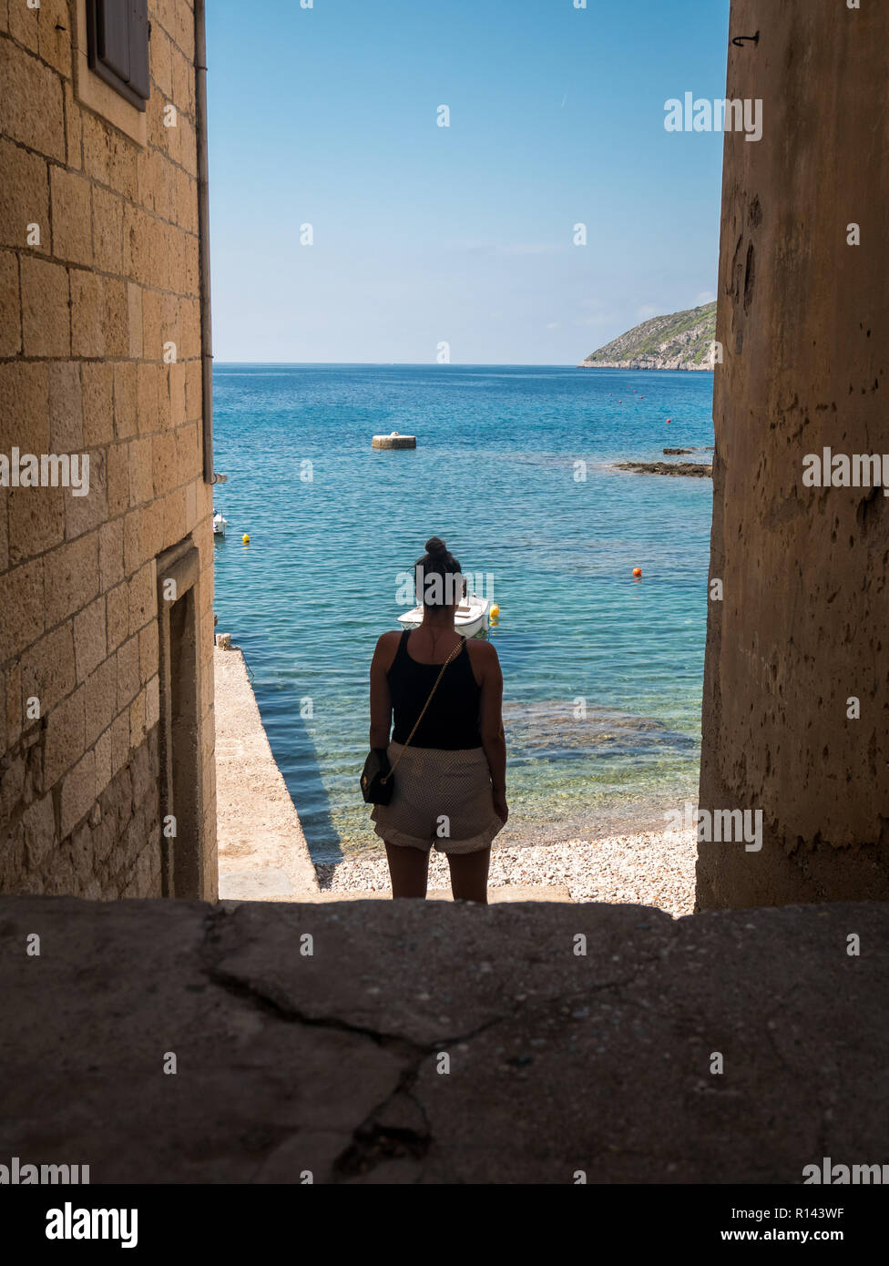 Yougn woman looking at sea de stone street sur île de Vis en Croatie Banque D'Images