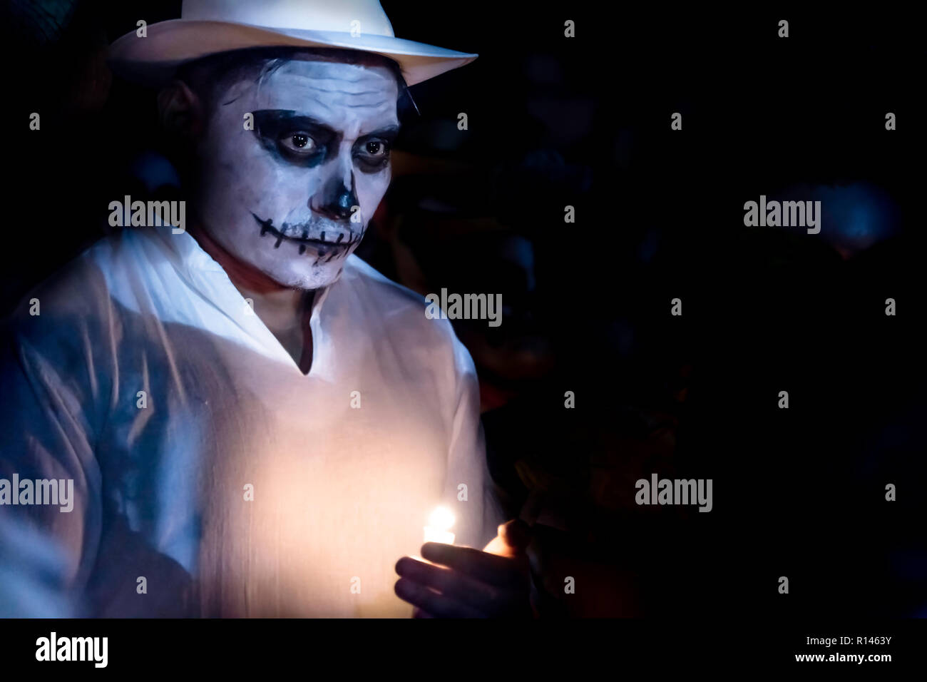 Merida, Mexique, Général Cementerio - 31 octobre 2018 : blanc homme sur mesure avec tête de make-up et white hat tenant une bougie à la parade pour dia de lo Banque D'Images