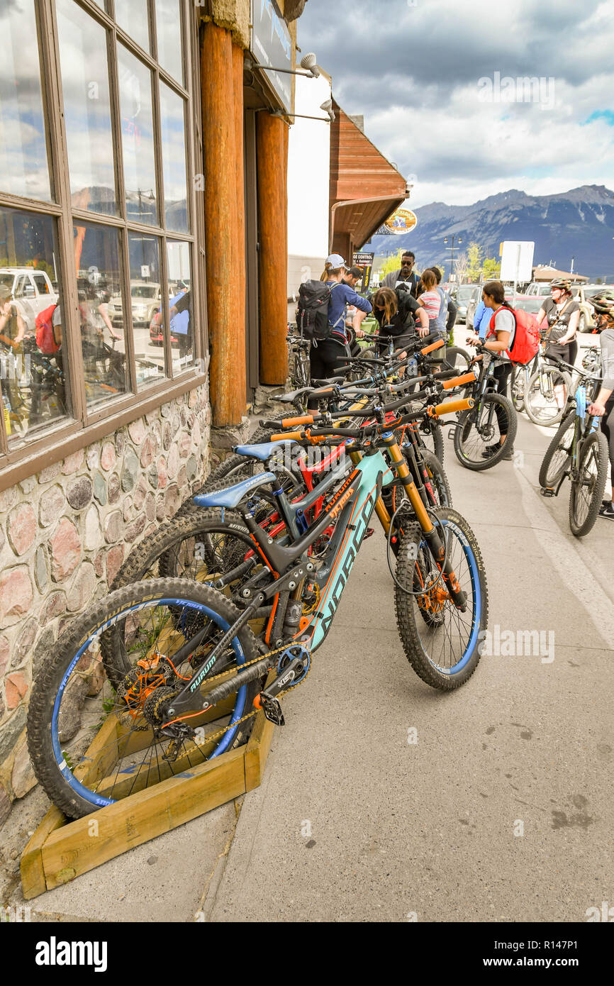 JASPER, AB, Canada - Juin 2018 : magasin de location de vélos à Jasper, en Alberta, avec des vélos alignés à l'extérieur et les cyclistes dans l'arrière-plan Banque D'Images