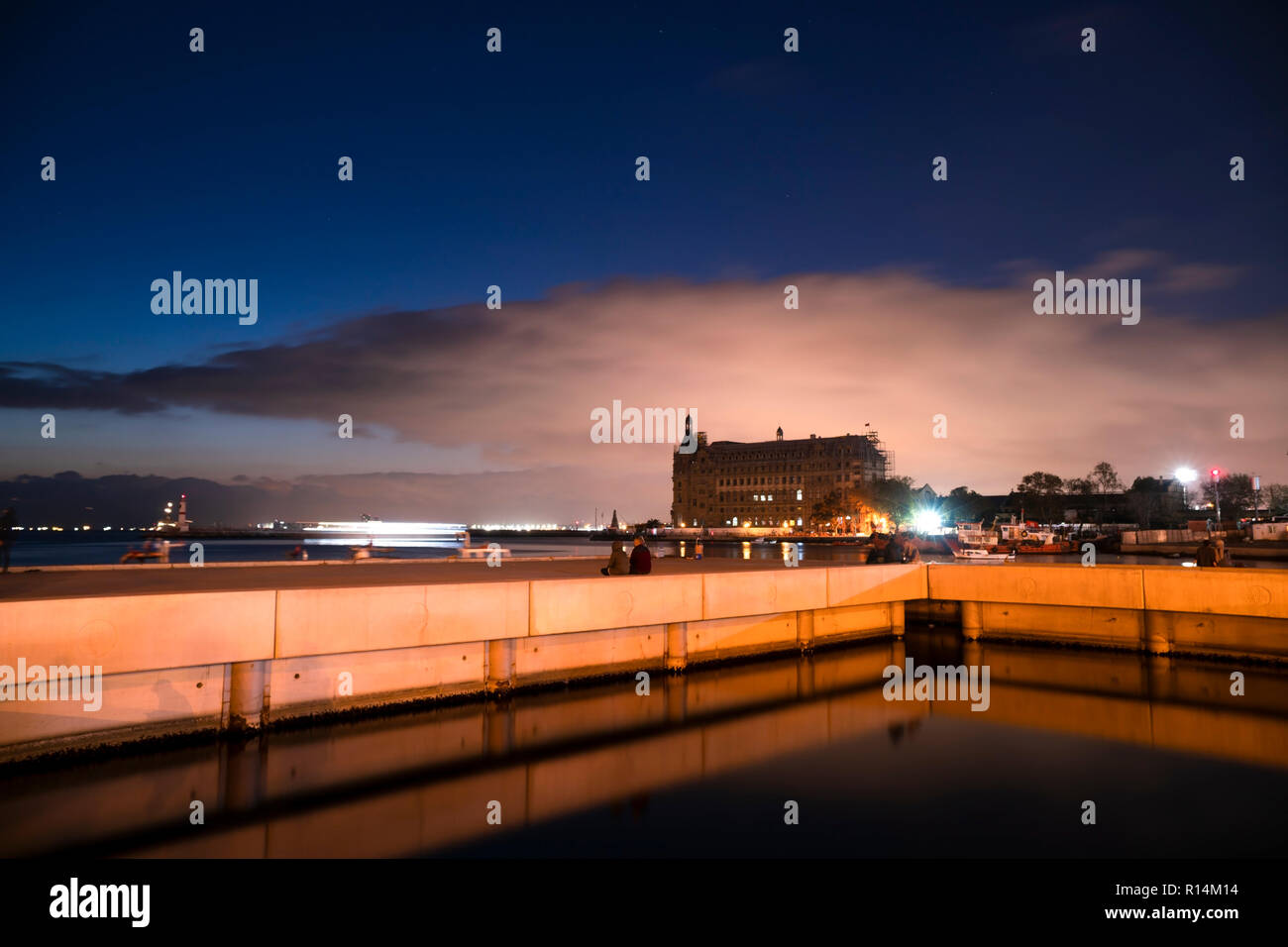 Longtemps exposé le bâtiment de la gare de Haydarpasa à Istanbul Kadikoy après le coucher du soleil avec une jetée en béton étrange et des réflexions sur eau Banque D'Images
