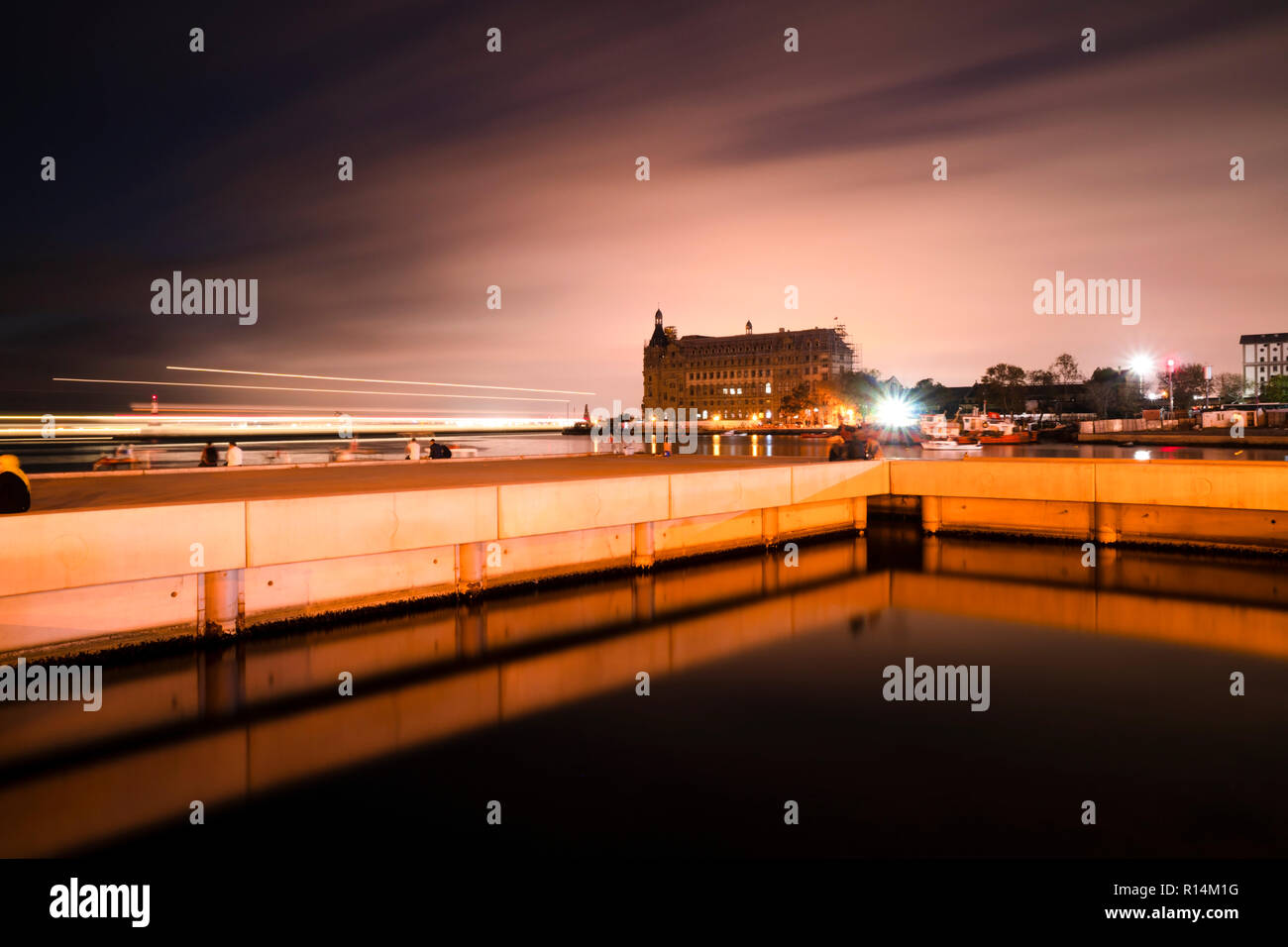 Longtemps exposé le bâtiment de la gare de Haydarpasa à Istanbul Kadikoy après le coucher du soleil avec une jetée en béton étrange et des réflexions sur eau Banque D'Images