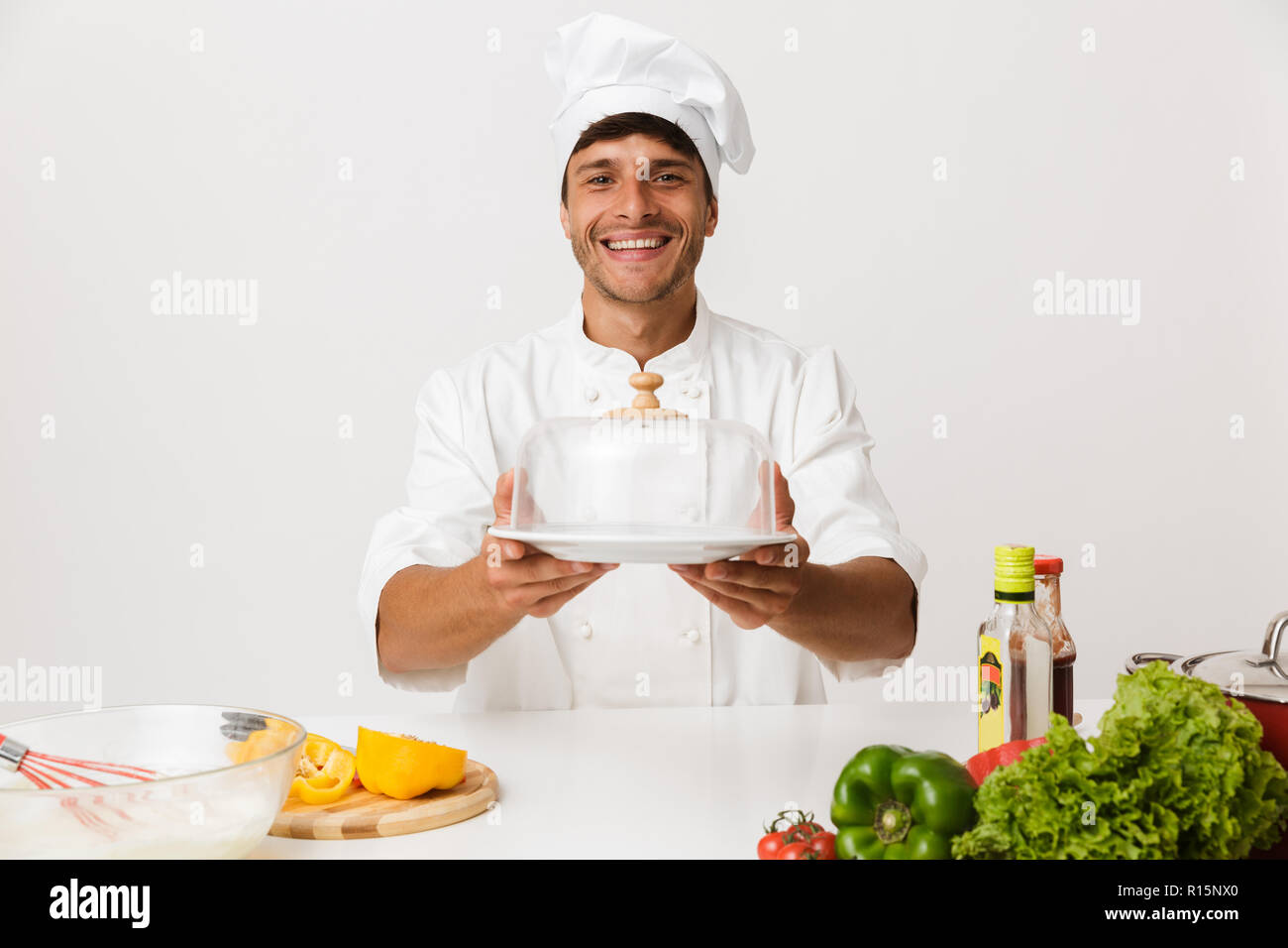 Image de beau jeune homme chef isolated over white wall background la cuisson. Banque D'Images