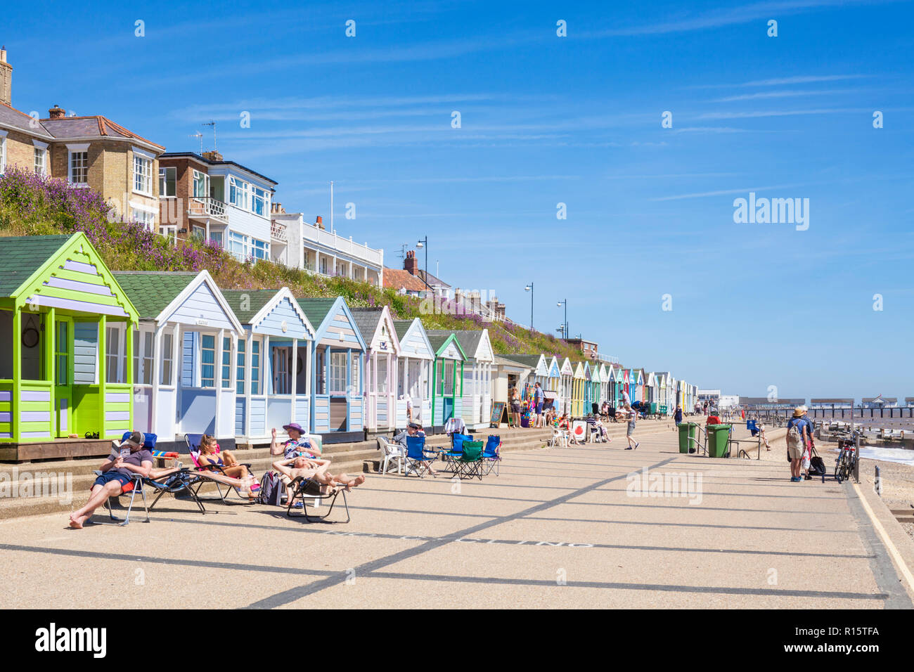 Cabines de plage de Southwold beach huts peint de couleurs vives, les vacanciers à la plage de Southwold North Parade East Anglia Suffolk Southwold England UK GO Europe Banque D'Images