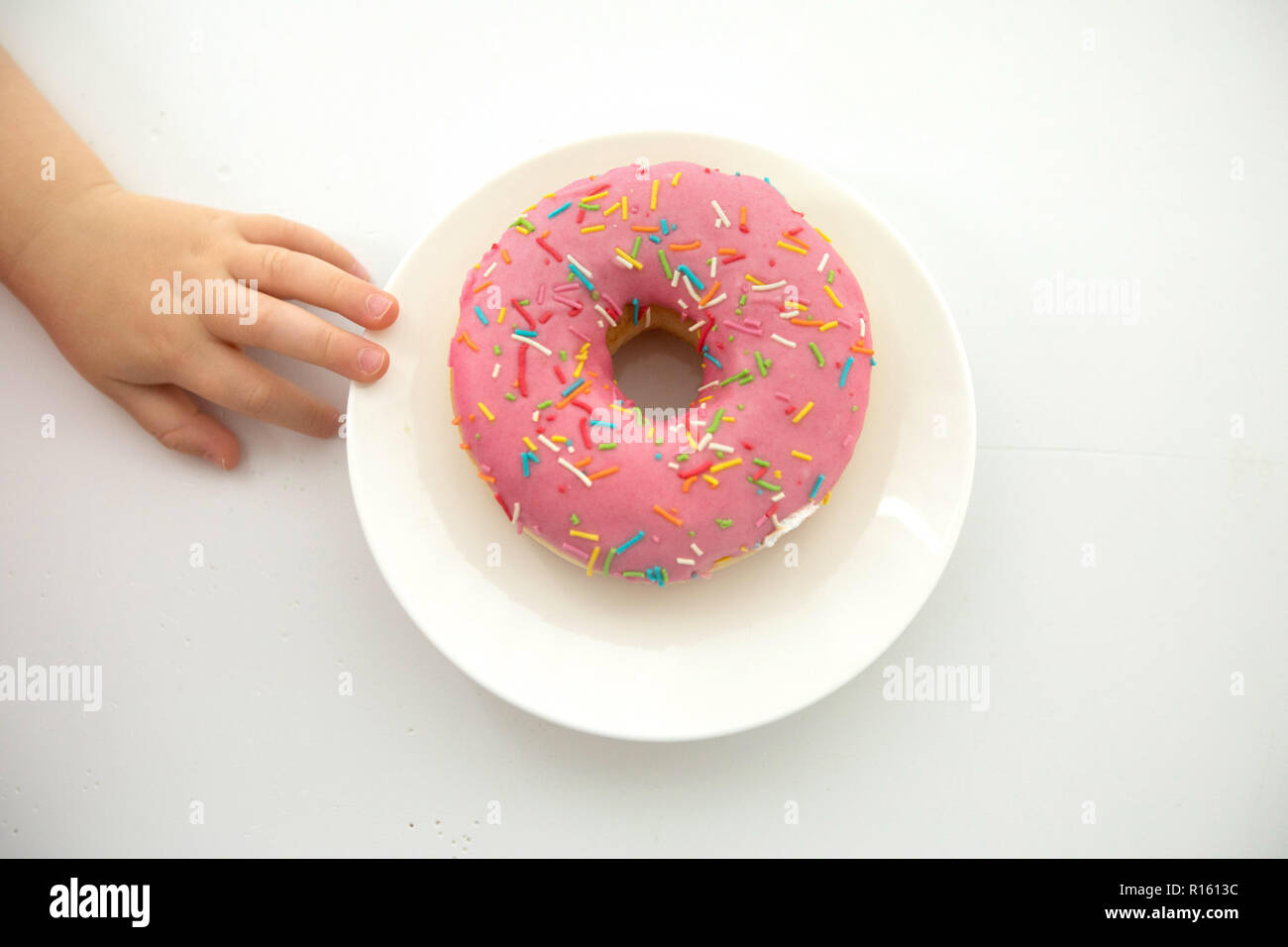 La récolte de l'enfant près de donut Banque D'Images