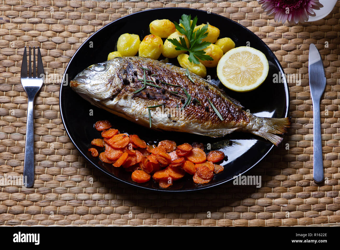 Un repas sain : la brème de mer, poêlée de carottes et pommes de terre au four Banque D'Images