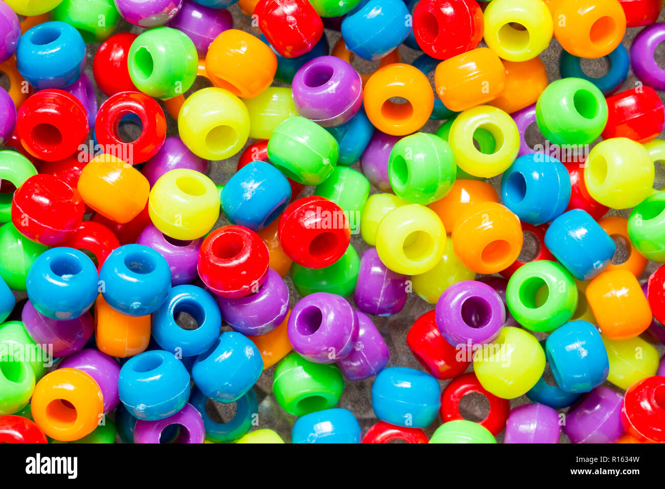 Un tas de collier de perles en plastique de couleur rouge, vert, jaune,  violet, orange et bleu Photo Stock - Alamy