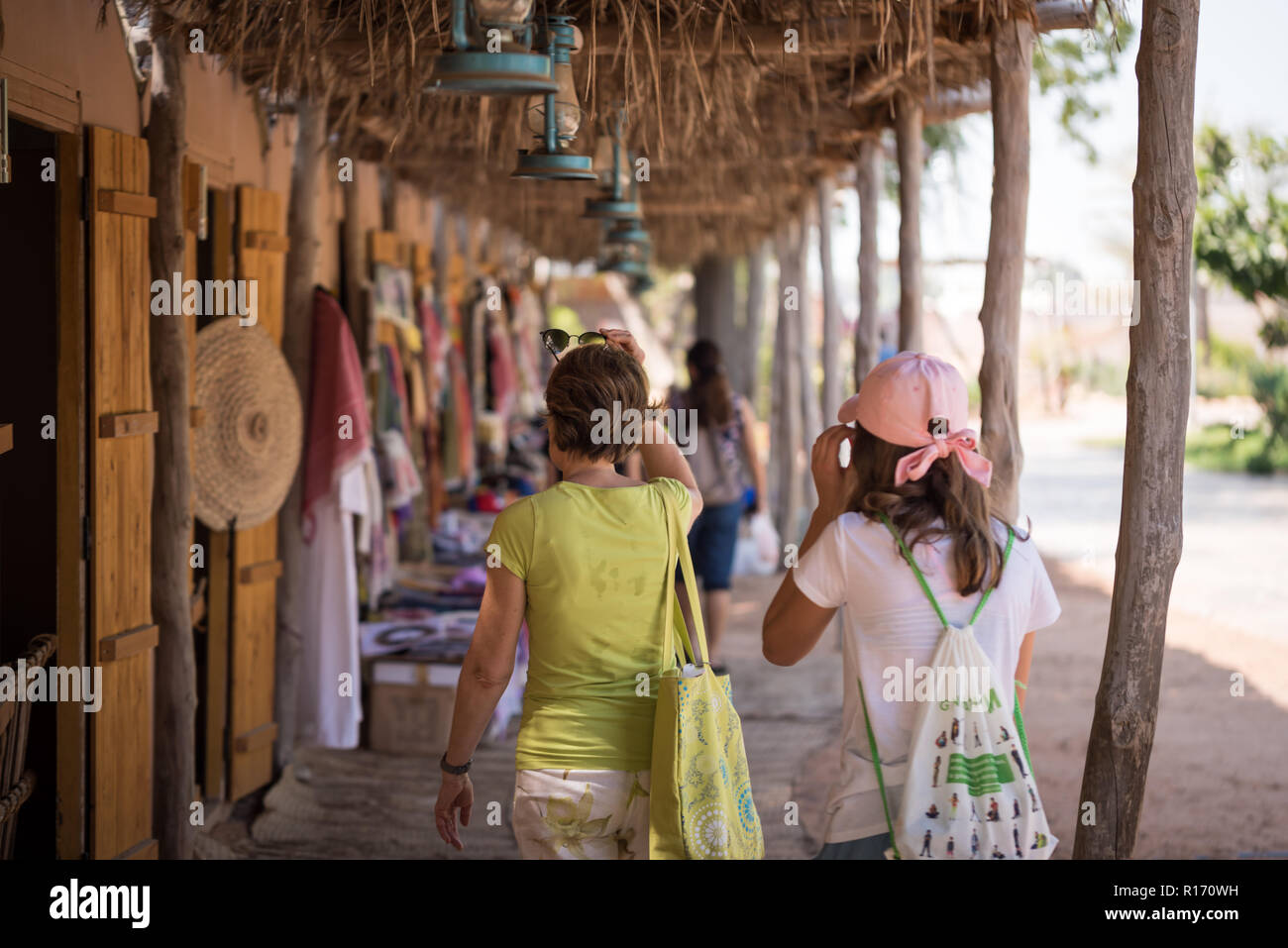 Les touristes européens visitant des boutiques d'artisanat dans la région de Heritage Village Abu Dhabi, UAE Banque D'Images