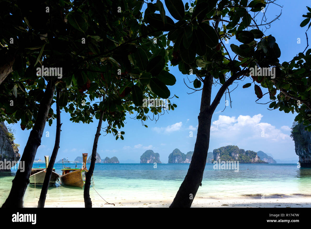 Plage tropicale tranquille avec la silhouette des arbres et bateau longtail dans l'île de Koh Hong, Pang Nga bay, Thaïlande Banque D'Images