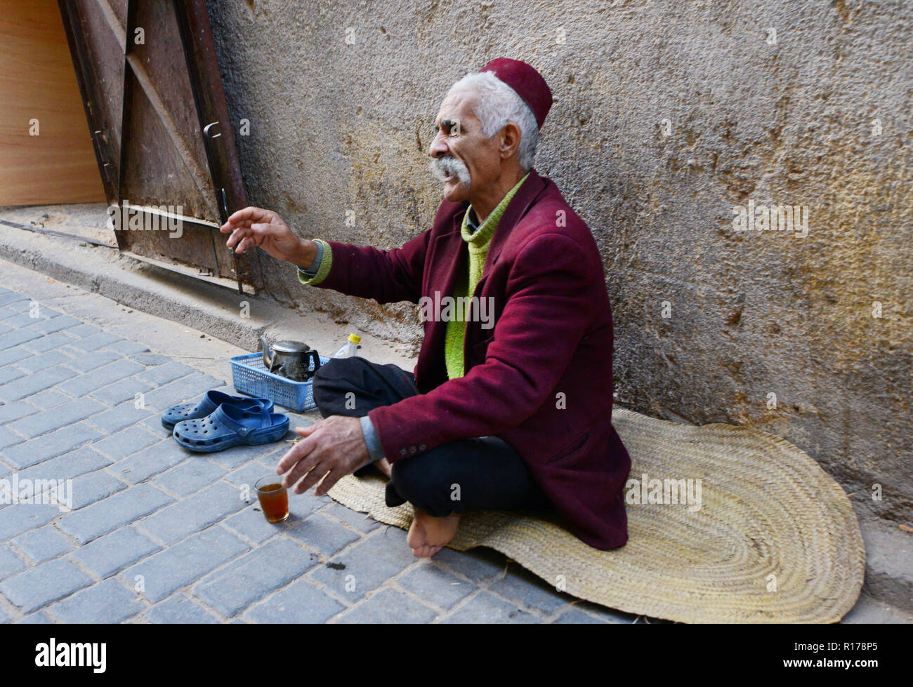 Habillé traditionnellement l'homme marocain marocain de boire une tasse de thé. Banque D'Images