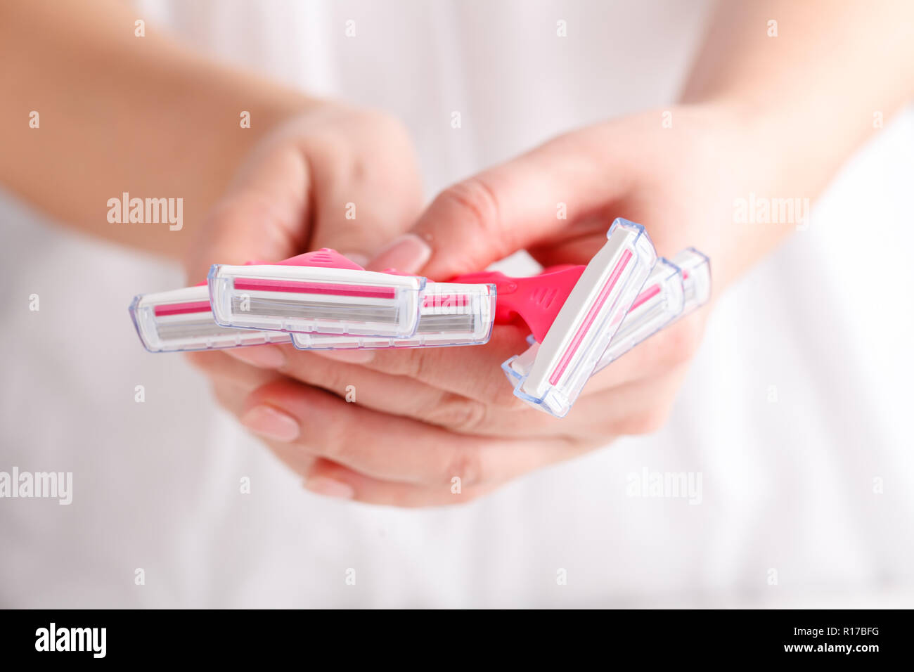 Rasoirs femme rose dans les mains sur le fond blanc. Série de rasoirs sur fond blanc. Les rasoirs jetables pour femmes rose Banque D'Images
