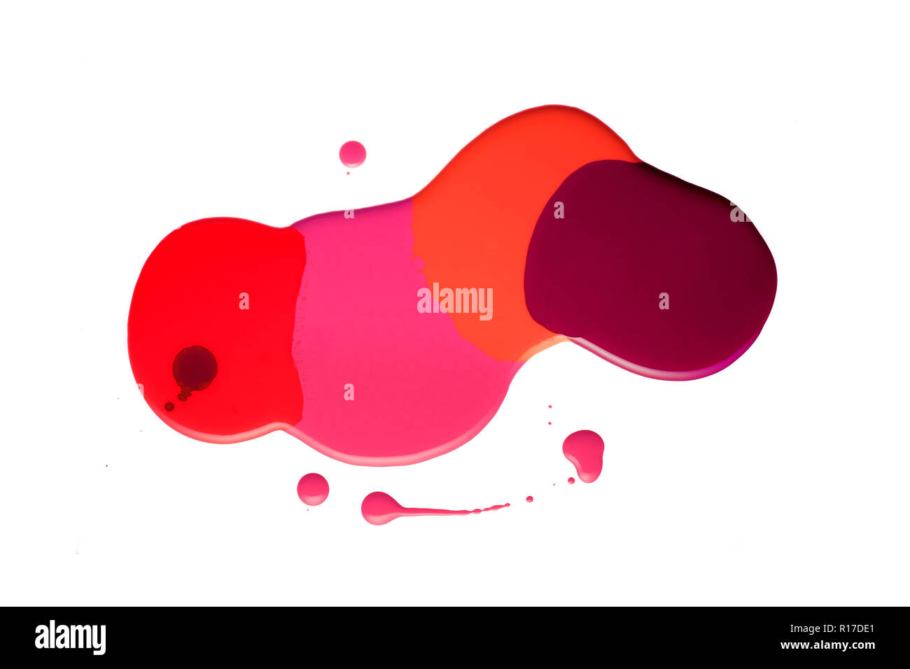 Vernis à ongles brillant dans les rouges, orange et rose sur fond blanc formant gloopy rythme irrégulier Banque D'Images