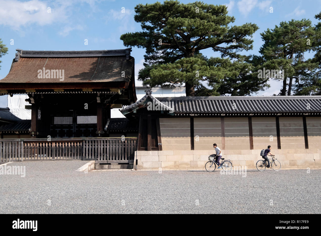 Les cyclistes à l'extérieur des portes du palais impérial à Kyoto, Japon Banque D'Images