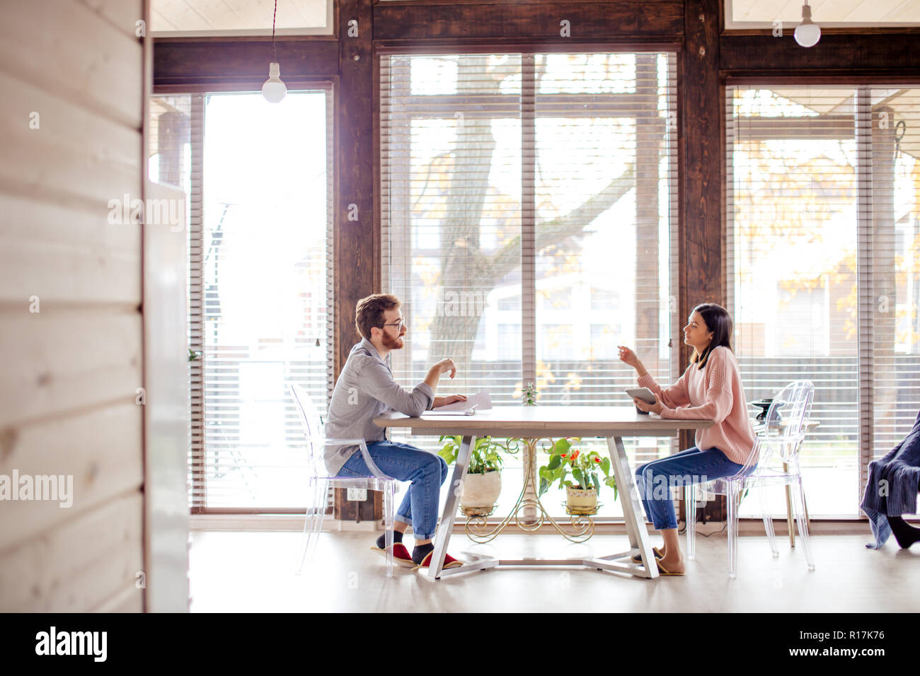 Un homme et une femme sont assis à une table en face de l'autre. Banque D'Images