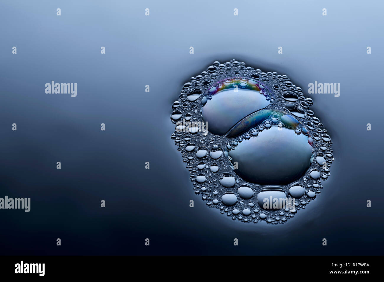 Vue rapprochée de la fusion des bulles sur la surface liquide Banque D'Images