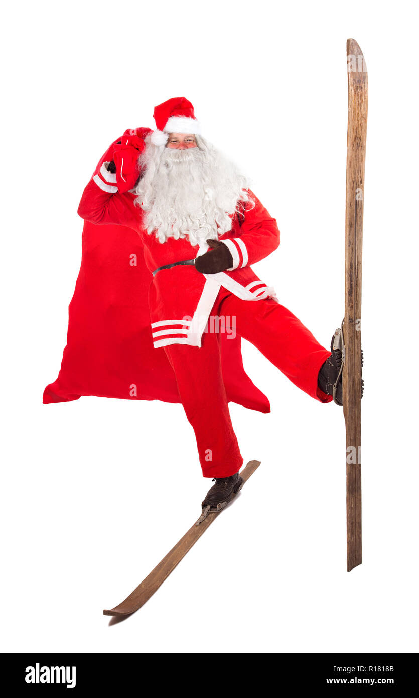 Funny Santa Claus se dresse sur un vieux rétro et ski grand sac, isolé sur fond blanc. Santa sportives sur les anciennes pistes de porter les cadeaux de Noël dans la Banque D'Images