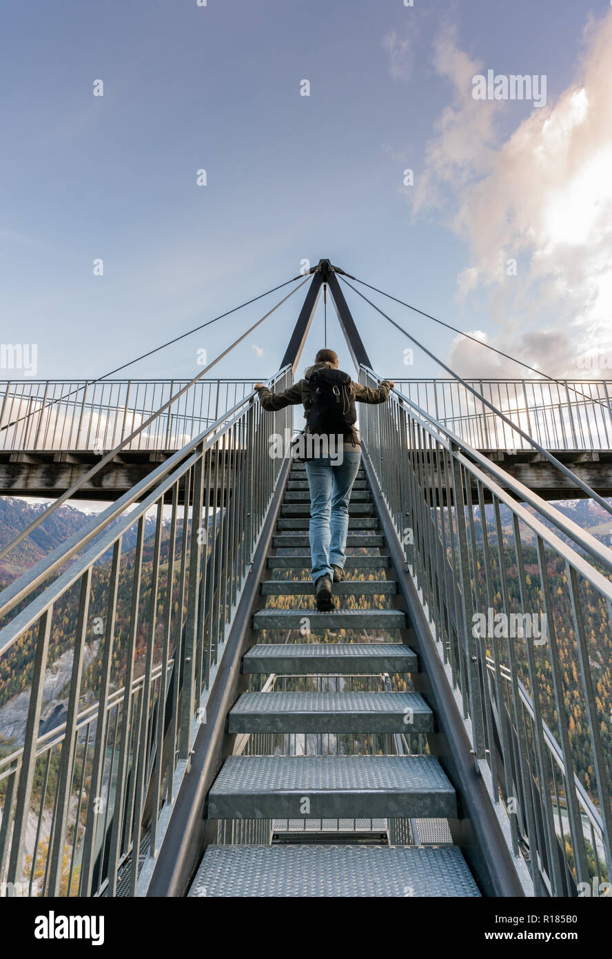 Female hiker grimper metal escaliers qui mènent jusqu'à une impressionnante vue panoramique et dans la plate-forme près de Grisons Flims en Suisse dans le cadre d'un b Banque D'Images