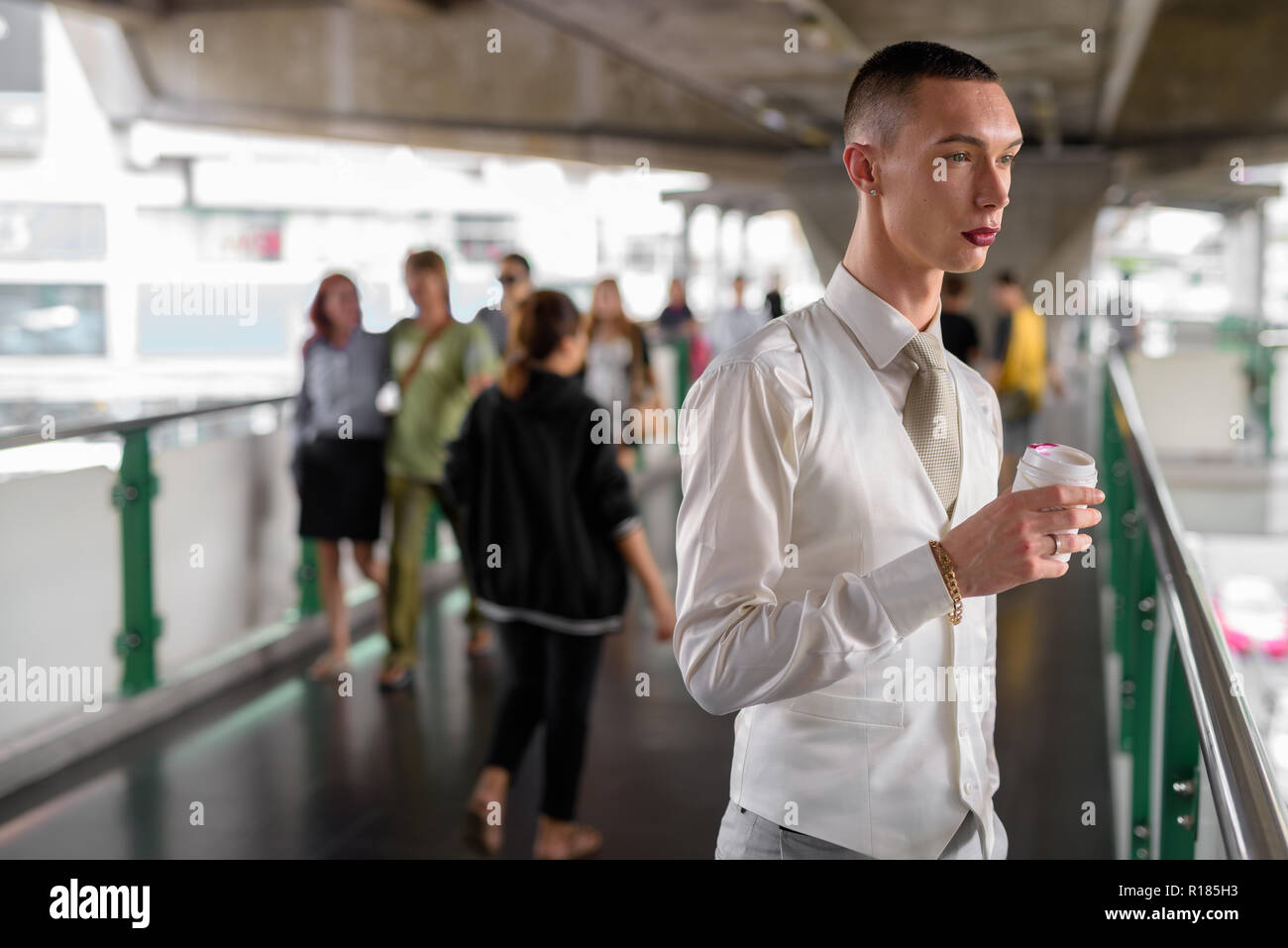 Les jeunes homosexuels androgyne LGTB businessman drinking coffee Banque D'Images