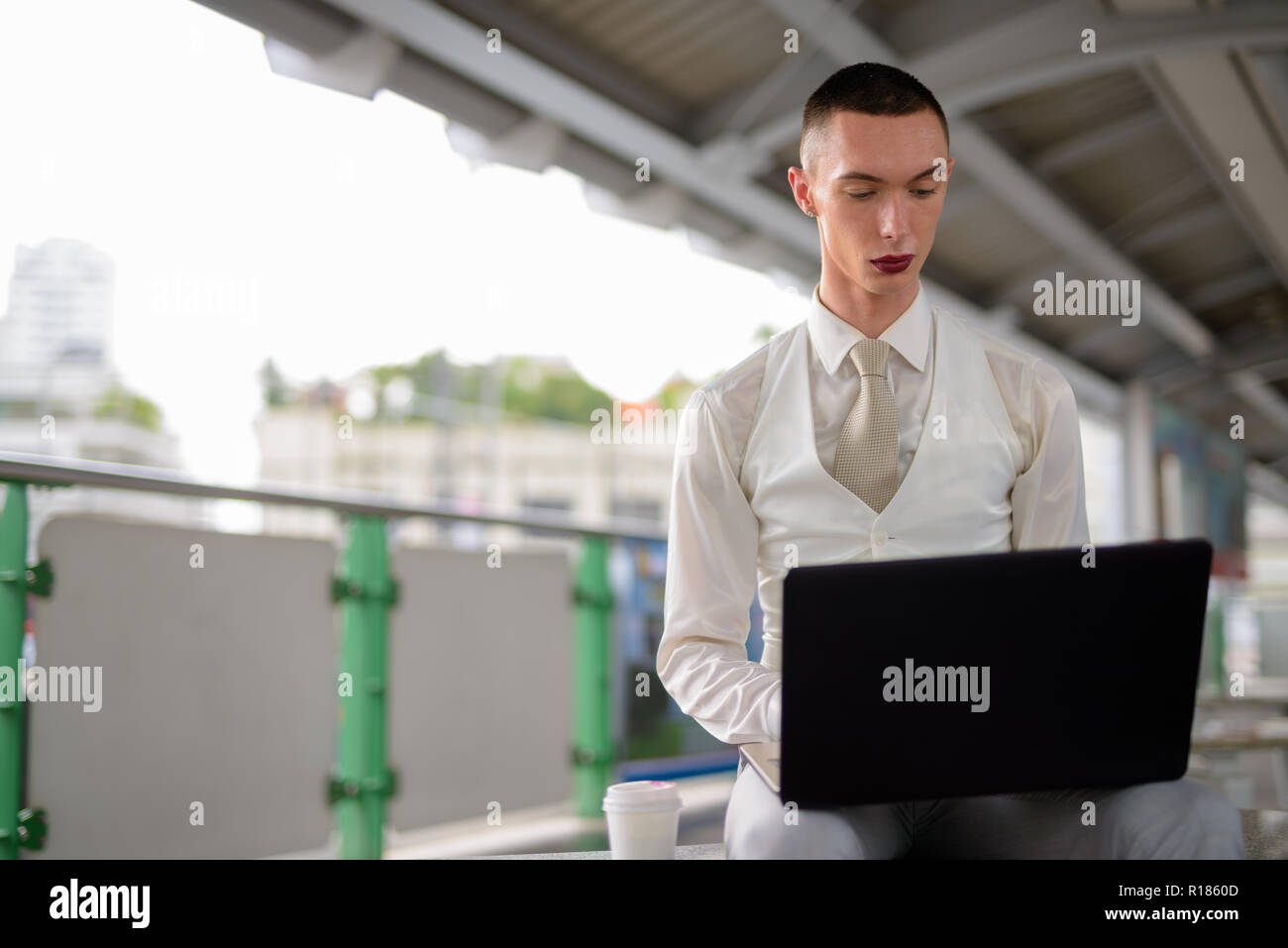 Les jeunes LGBT homosexuel androgyne businessman using laptop computer Banque D'Images