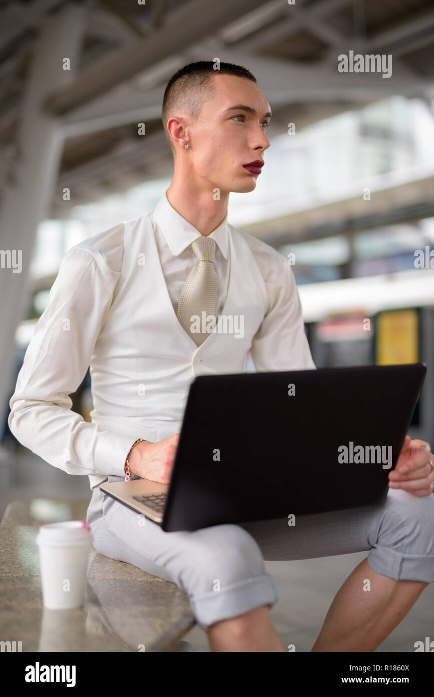 Les jeunes LGBT homosexuel androgyne businessman using laptop computer Banque D'Images