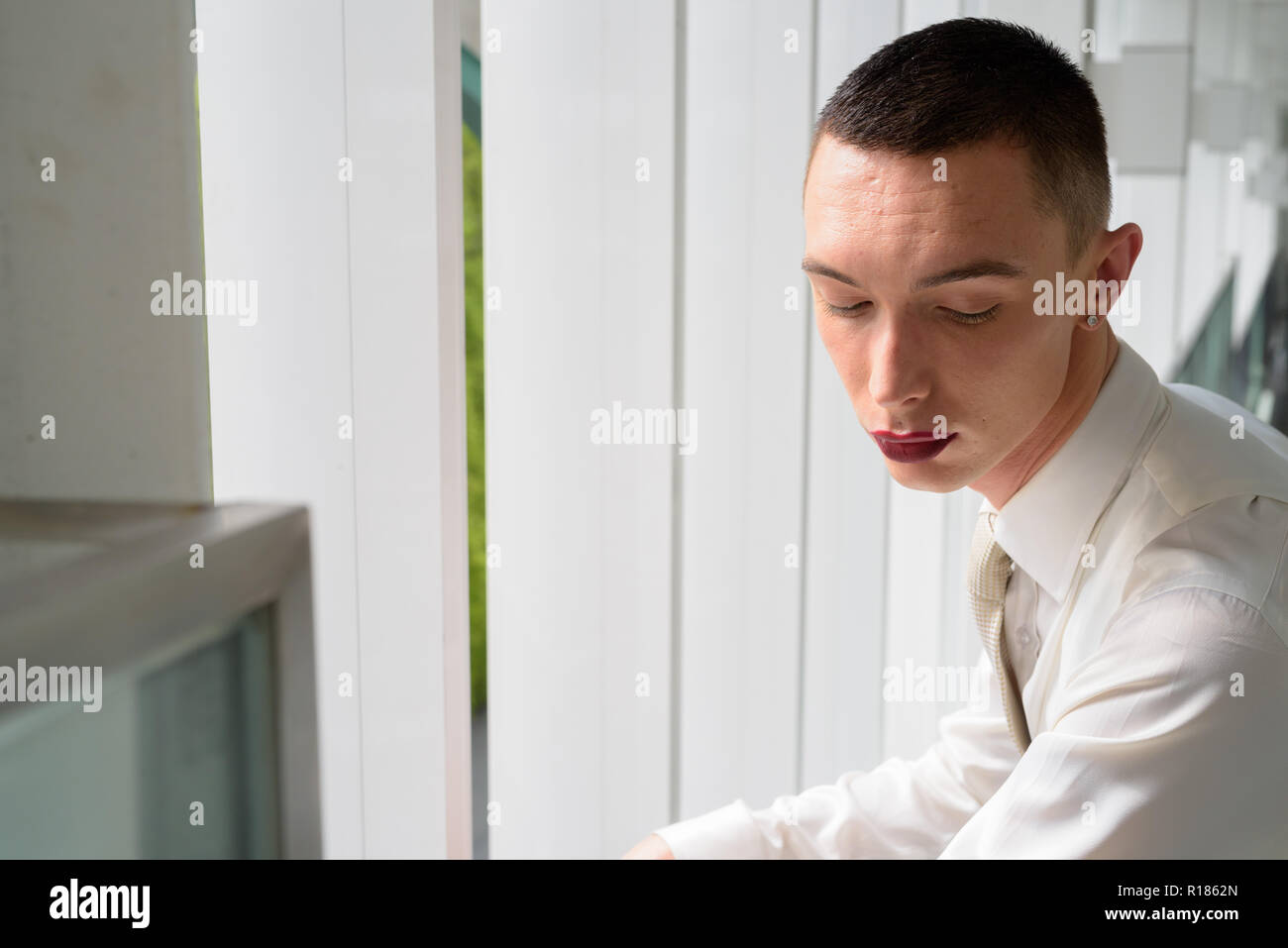 Young businessman wearing LGTB homosexuel androgyne lipstick Banque D'Images