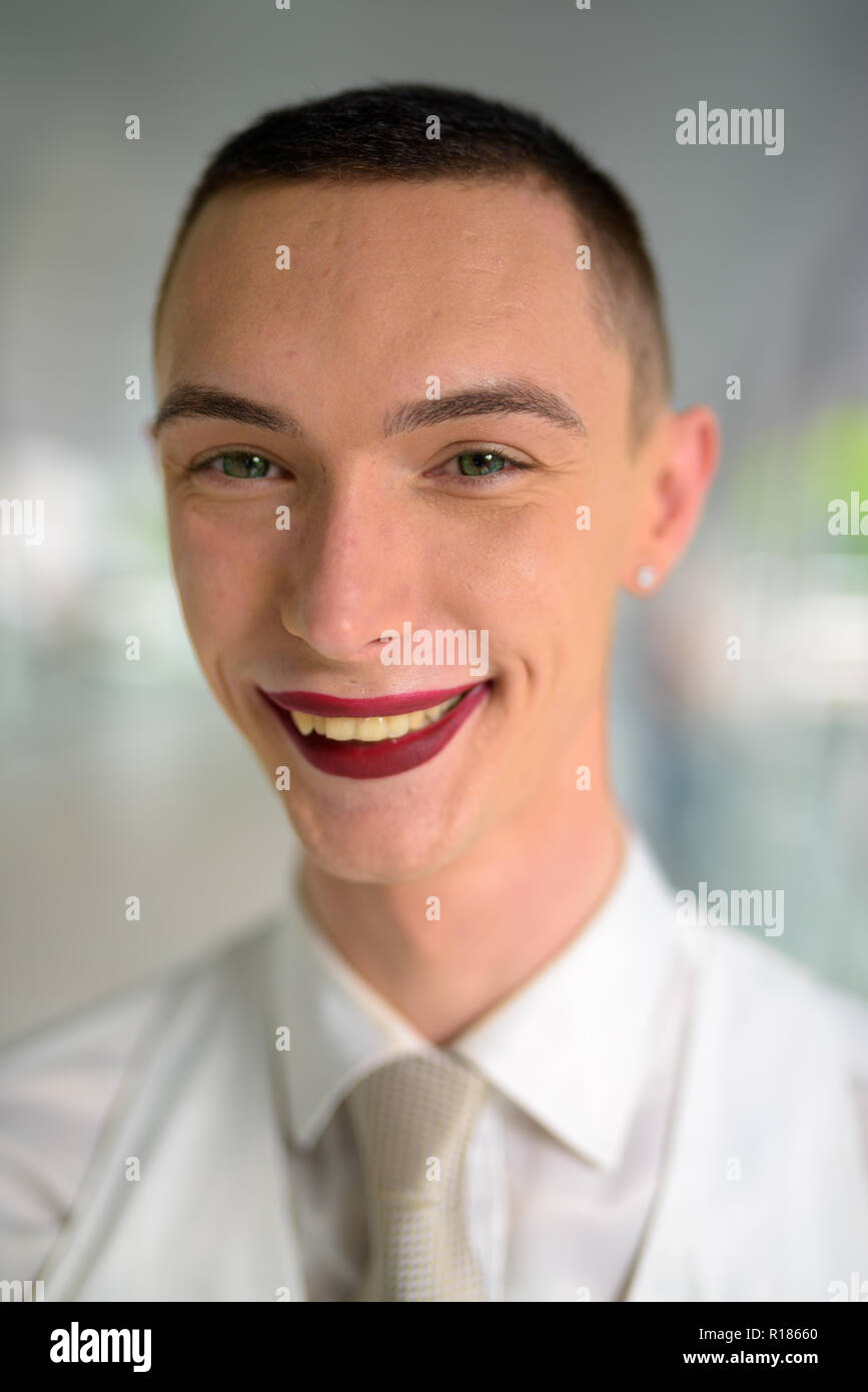 Young businessman wearing LGTB homosexuel androgyne lipstick and smiling Banque D'Images