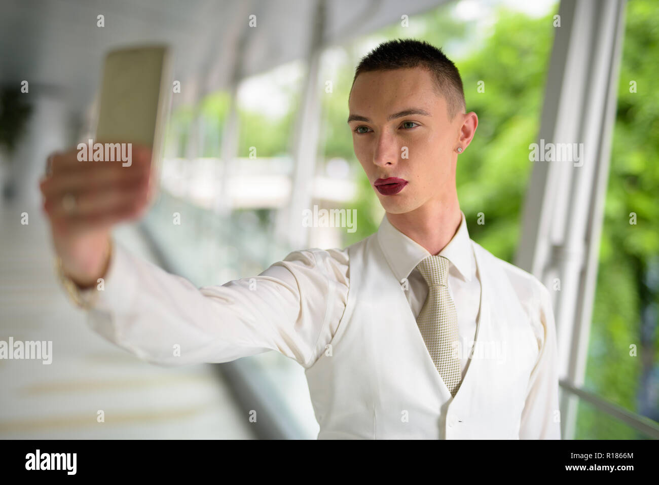 Les jeunes homosexuels en tenant l'homme androgyne LGTB selfies avec téléphone Banque D'Images