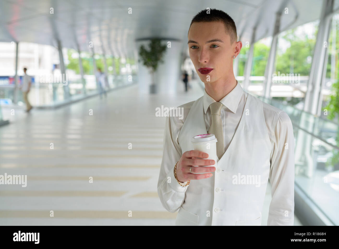 Les jeunes homosexuels androgyne LGTB businessman drinking coffee Banque D'Images