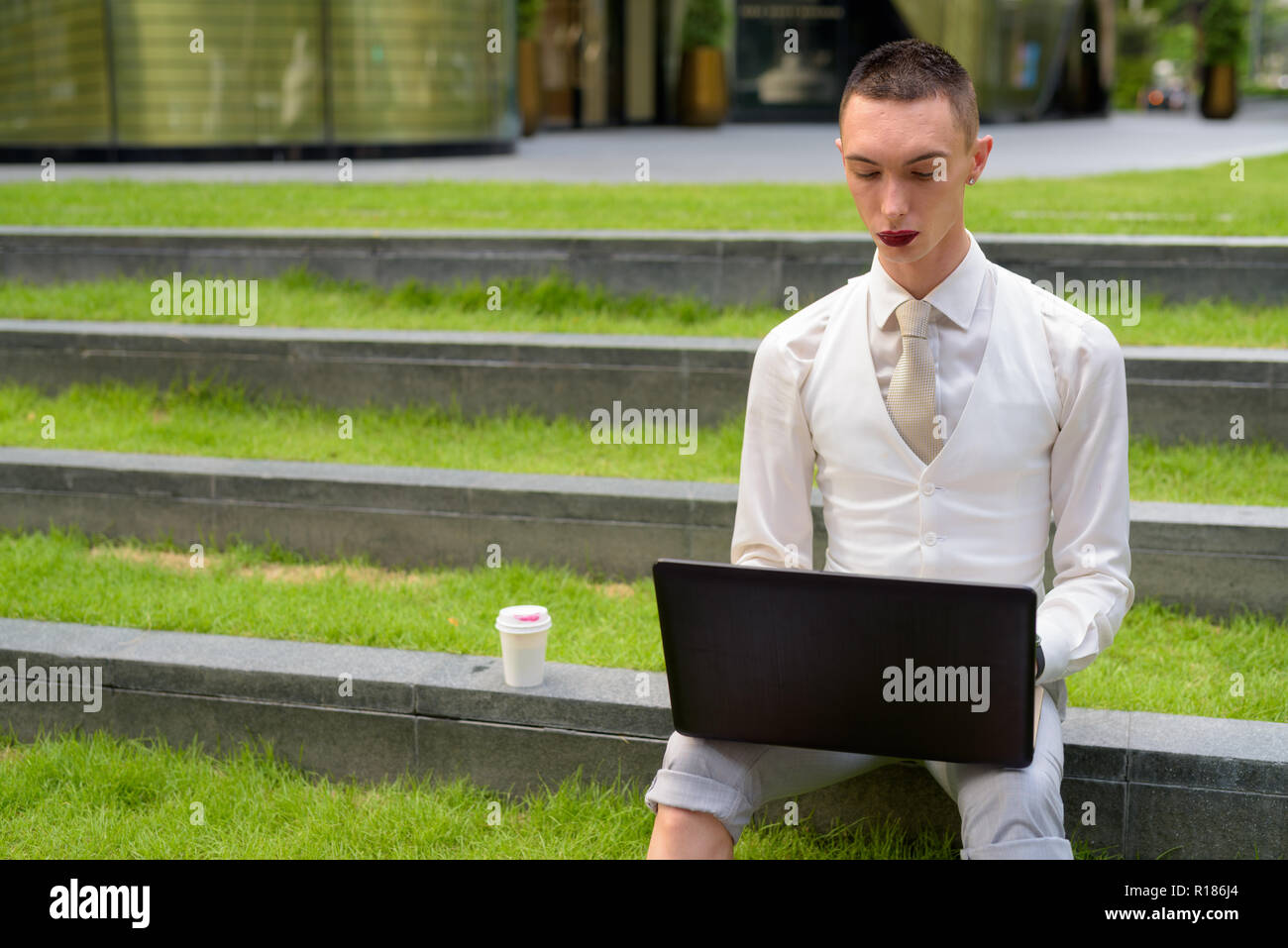 LGTB businessman sitting on stairs while using laptop computer Banque D'Images