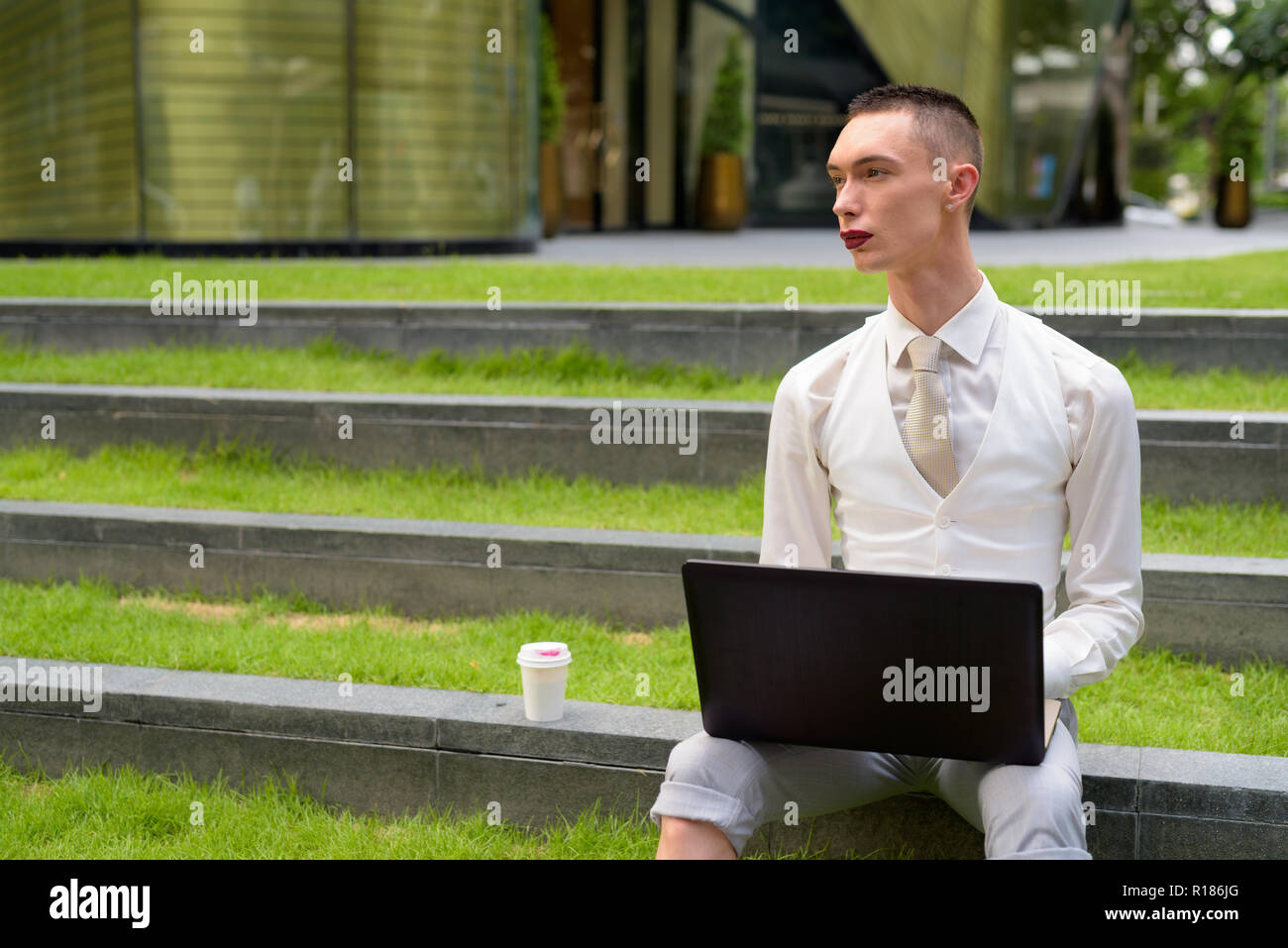 LGTB businessman sitting on stairs while using laptop computer Banque D'Images
