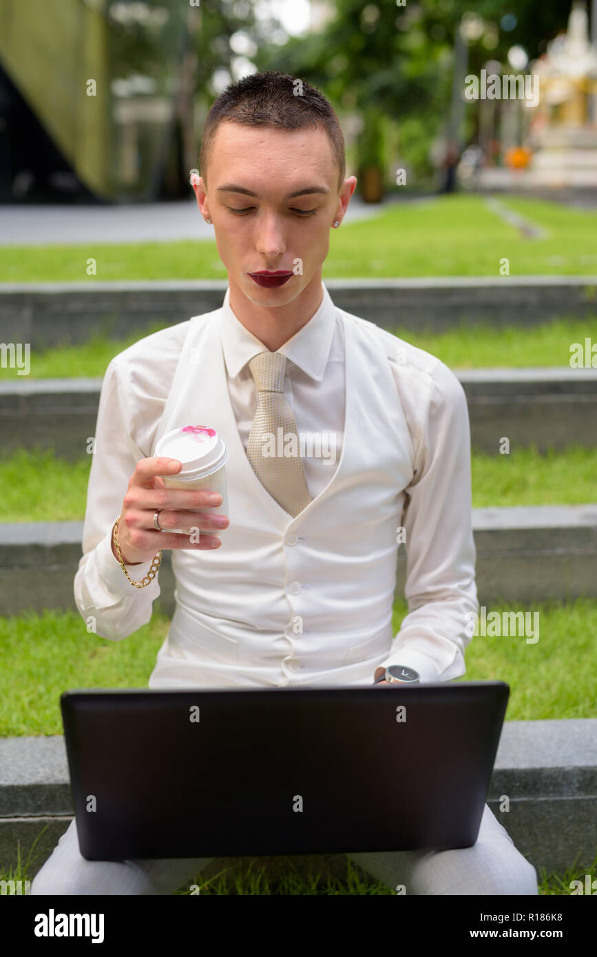 LGTB businessman sitting on stairs while using laptop computer Banque D'Images