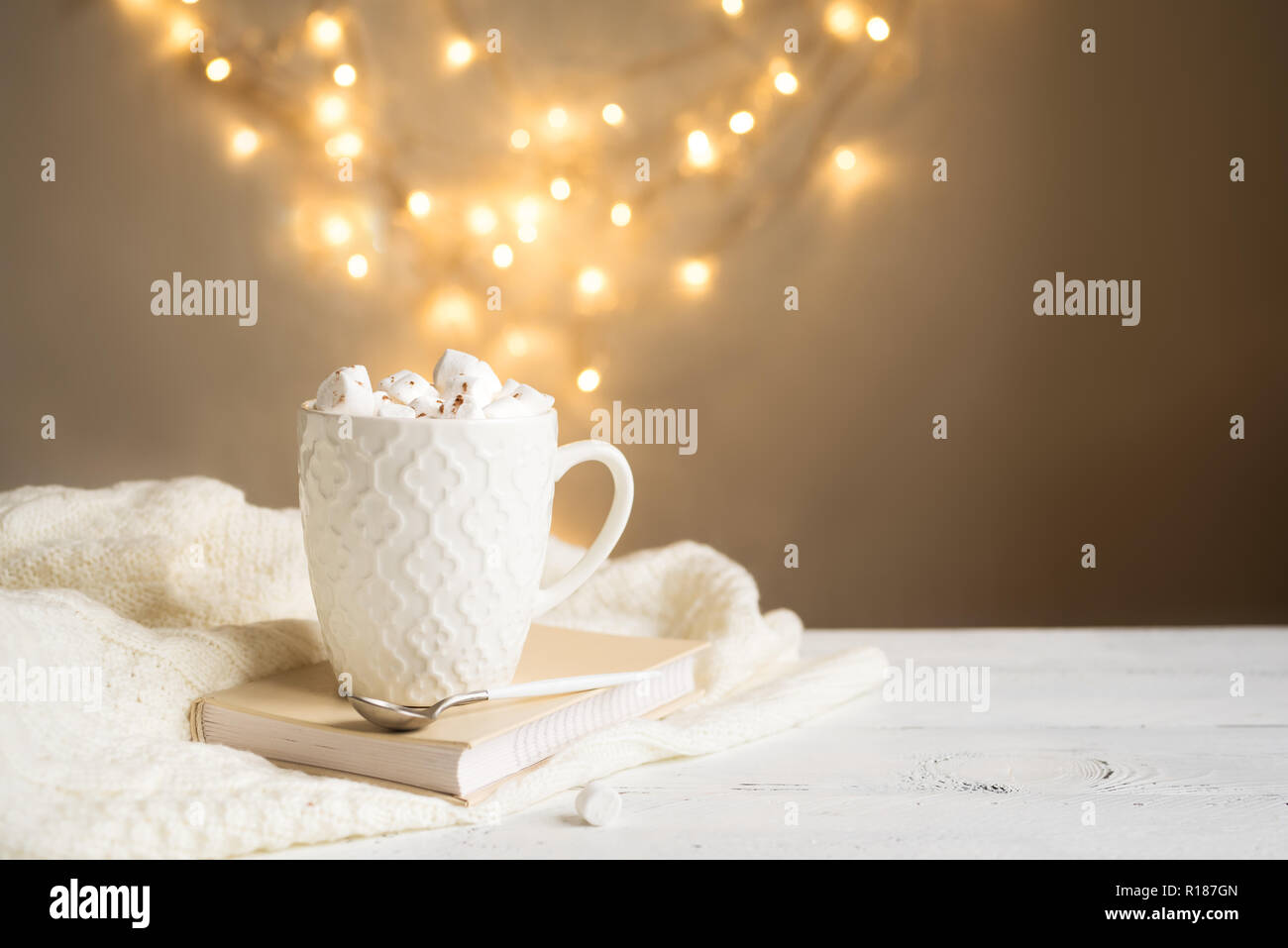 Chocolat chaud avec des guimauves en blanc mug, copiez l'espace. Boisson cacao chaud pour Noël et les vacances d'hiver, avec écharpe, phares sur tableau blanc. Banque D'Images