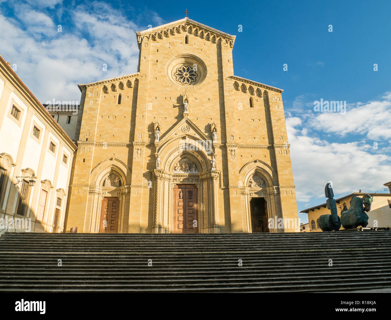 Catholique romaine gothique Cathédrale des Saints Pierre & Donato dans la ville d'Arezzo, Toscane, Italie, avec une statue de cheval en bronze (à droite) Banque D'Images