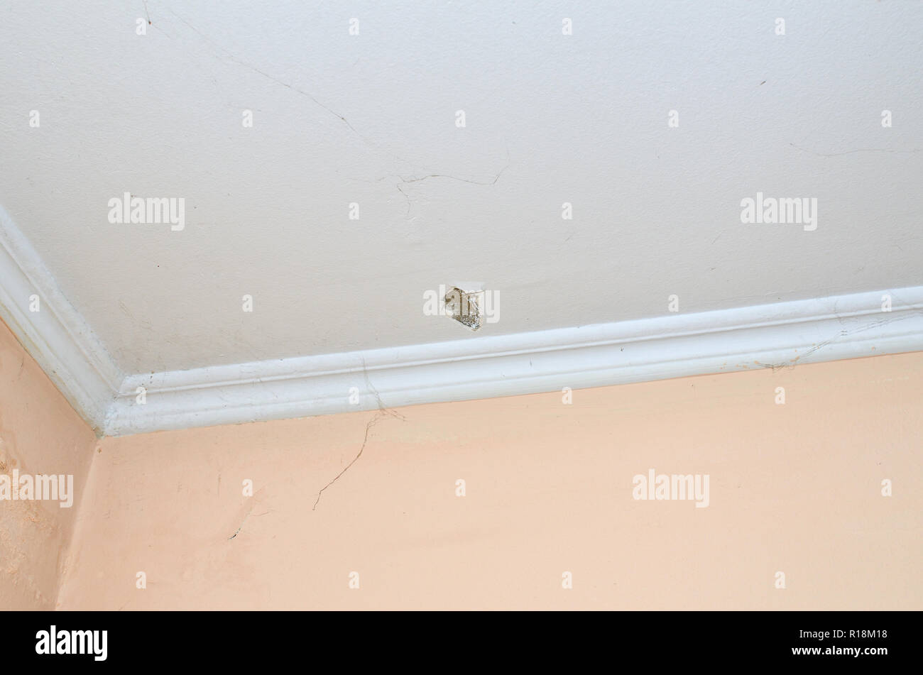 Plafond par une fissure et mur avec des parties d'une araignée Banque D'Images