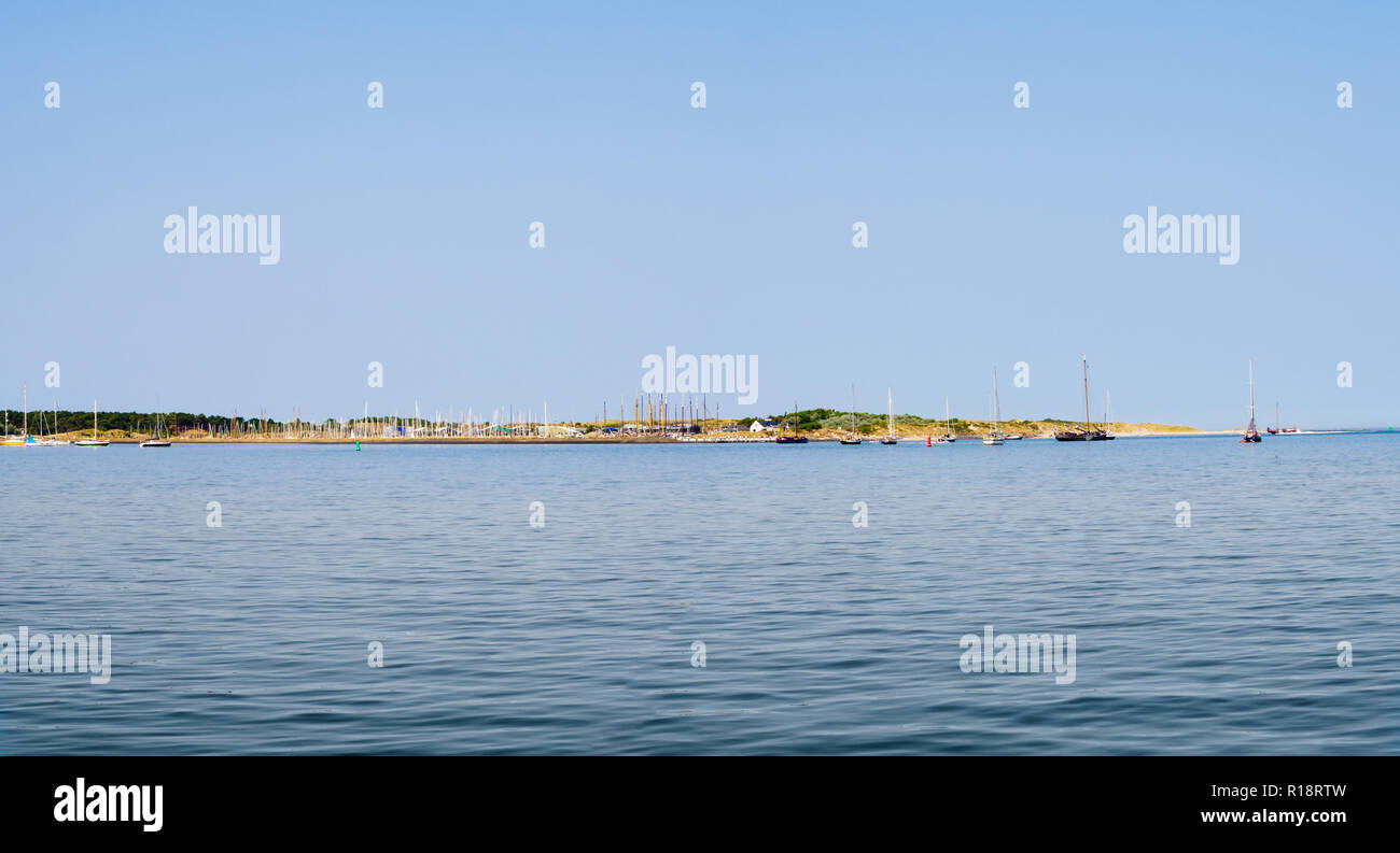 Toits de île Vlieland avec voiliers, les dunes et l'entrée de marina à partir de la mer des Wadden, Pays-Bas Banque D'Images