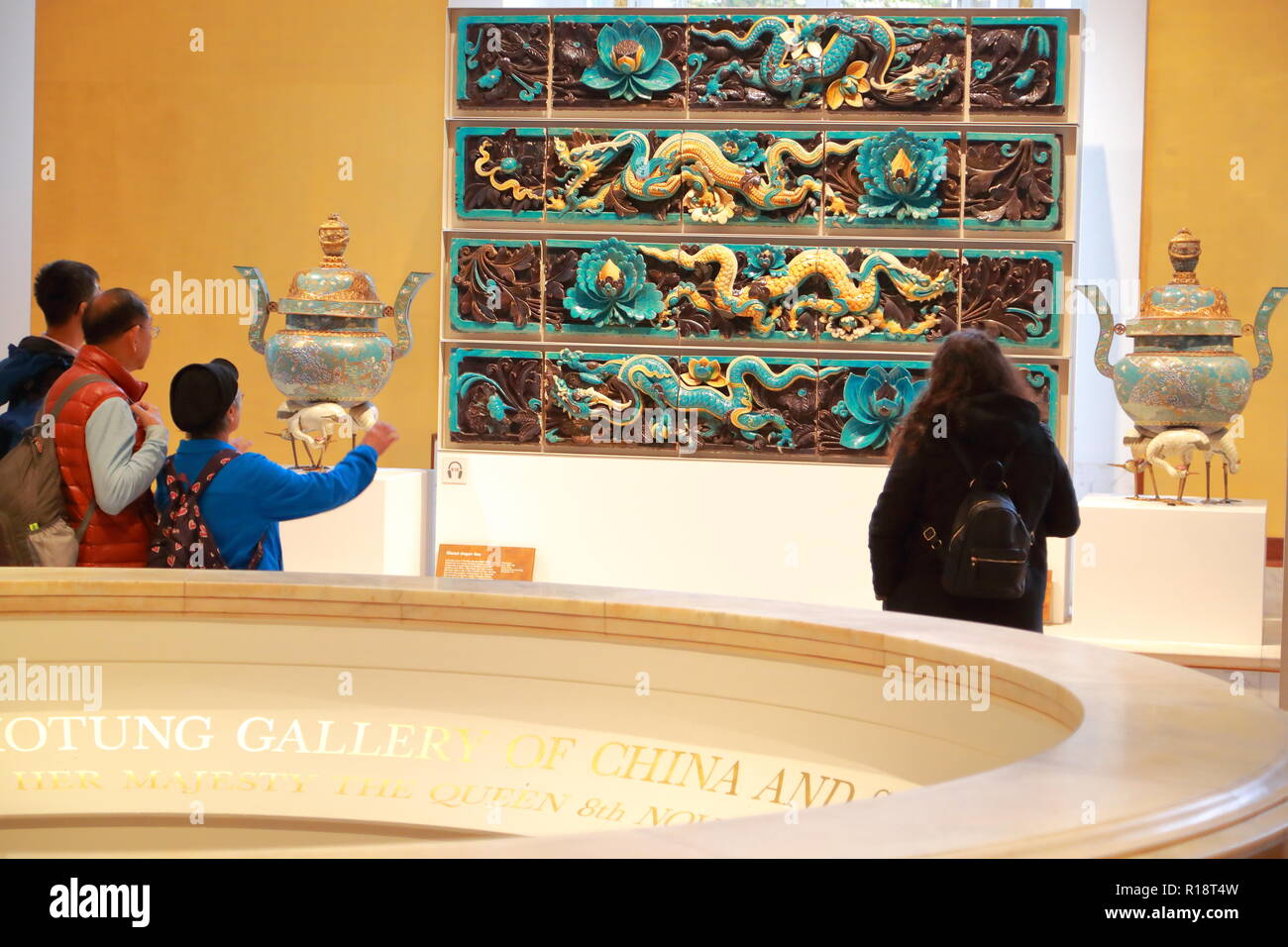 Les visiteurs admirer émaillés carreaux dragon chinois au British Museum, London, UK Banque D'Images