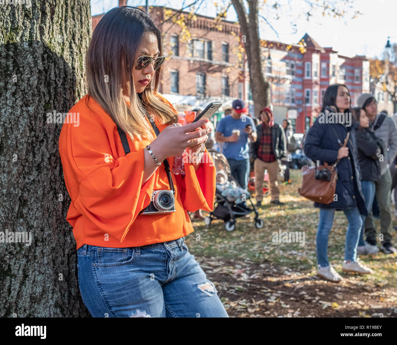 Une femme textos sur son téléphone portable à Harvard Square, Cambridge, MA Banque D'Images