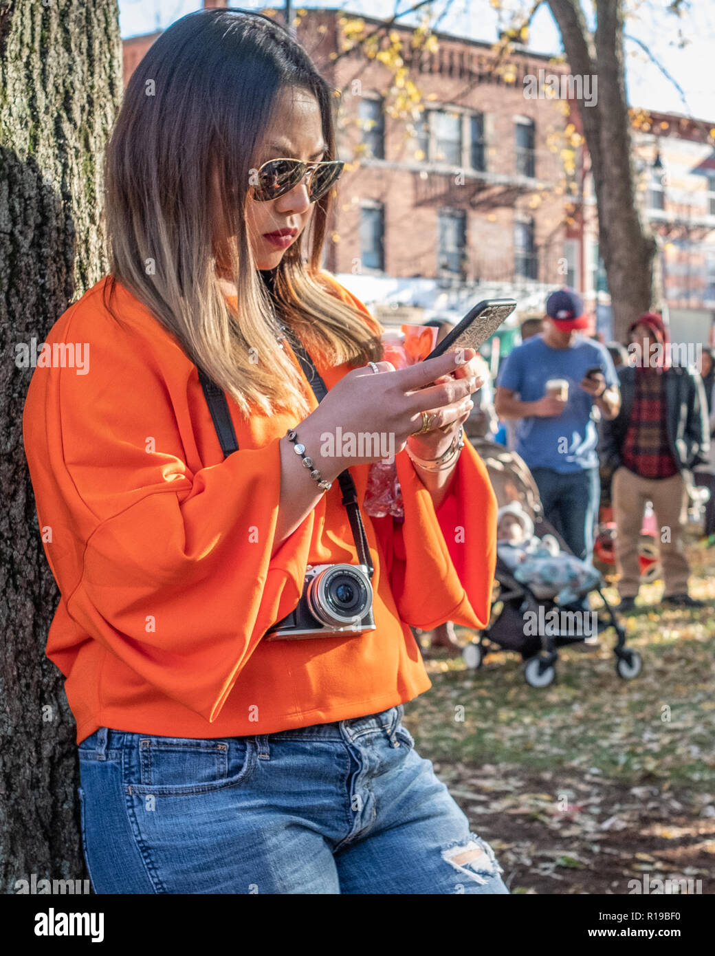 Une femme textos sur son téléphone portable à Harvard Square, Cambridge, MA Banque D'Images